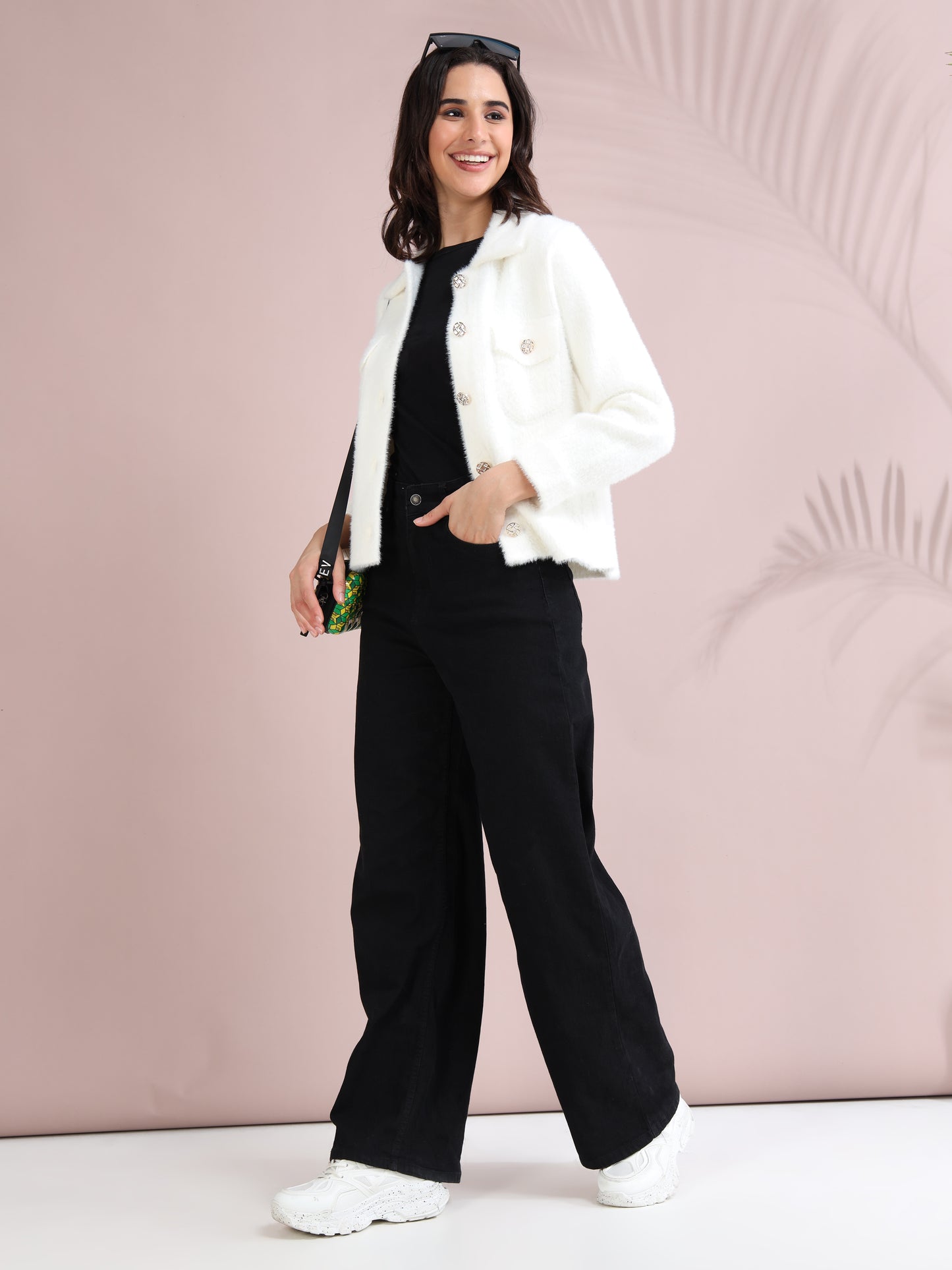 Model wearing women's white collared winter jacket styled with black wide-leg pants and white sneakers.