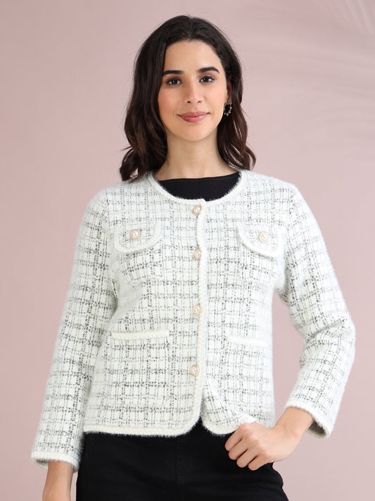 Woman wearing a white check tweed cardigan sweater with pearl button closure and front pockets.
