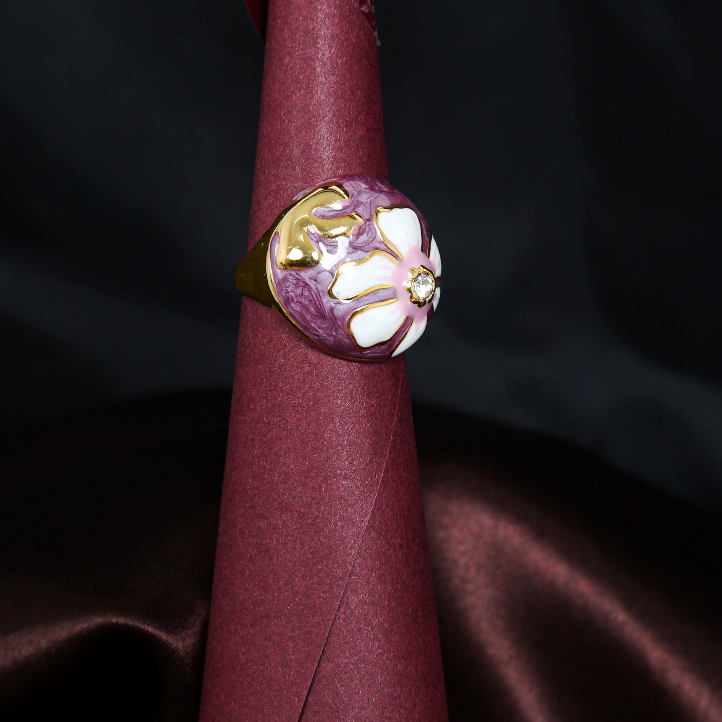 Elegant anti-tarnish floral ring with purple enamel background, gold detailing, and a sparkling diamond centerpiece