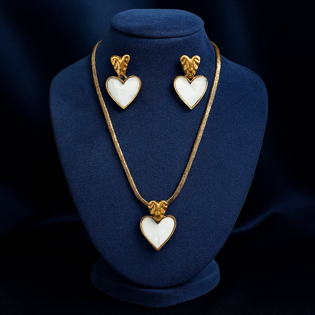 Gold heart-shaped pendant necklace with matching earrings, featuring a white stone center