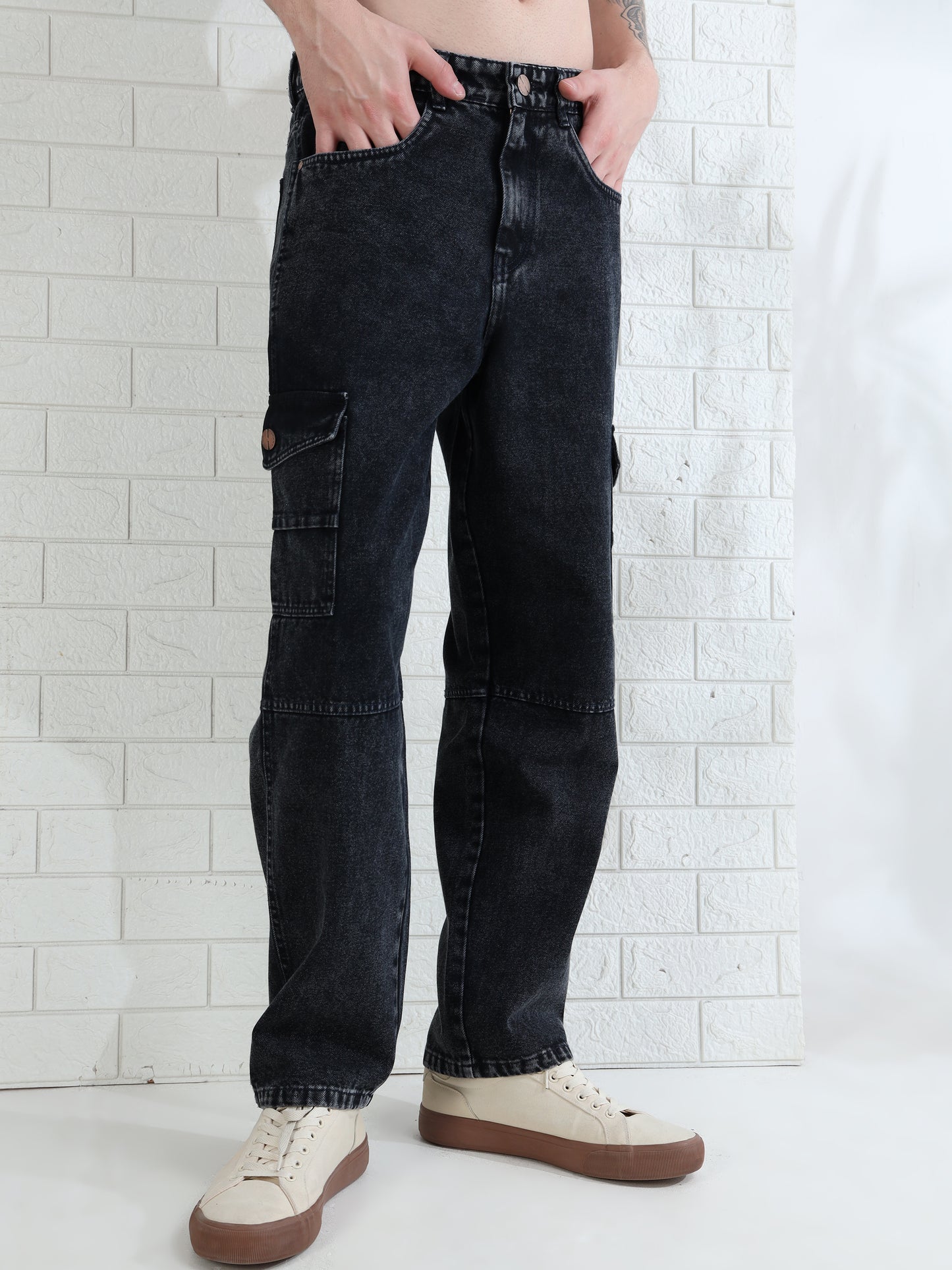 Casual men's washed black jeans paired with sneakers studio look