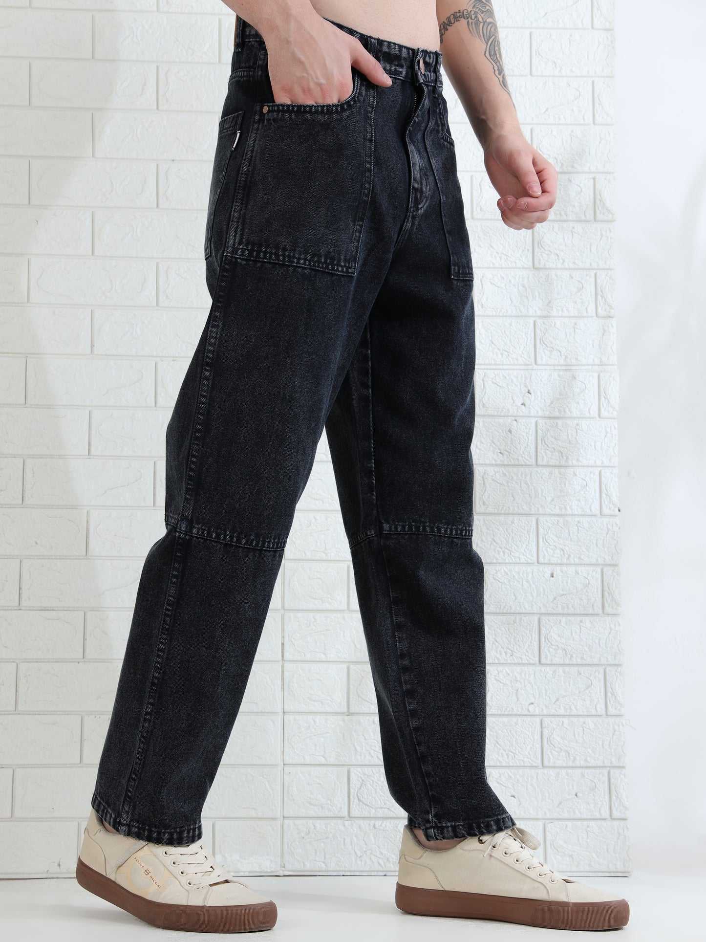 Casual men's washed black jeans paired with sneakers studio look
