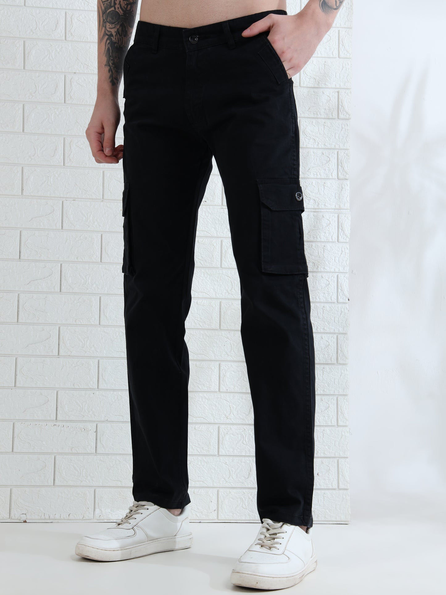 Casual men's black cargo pants paired with white sneakers studio look