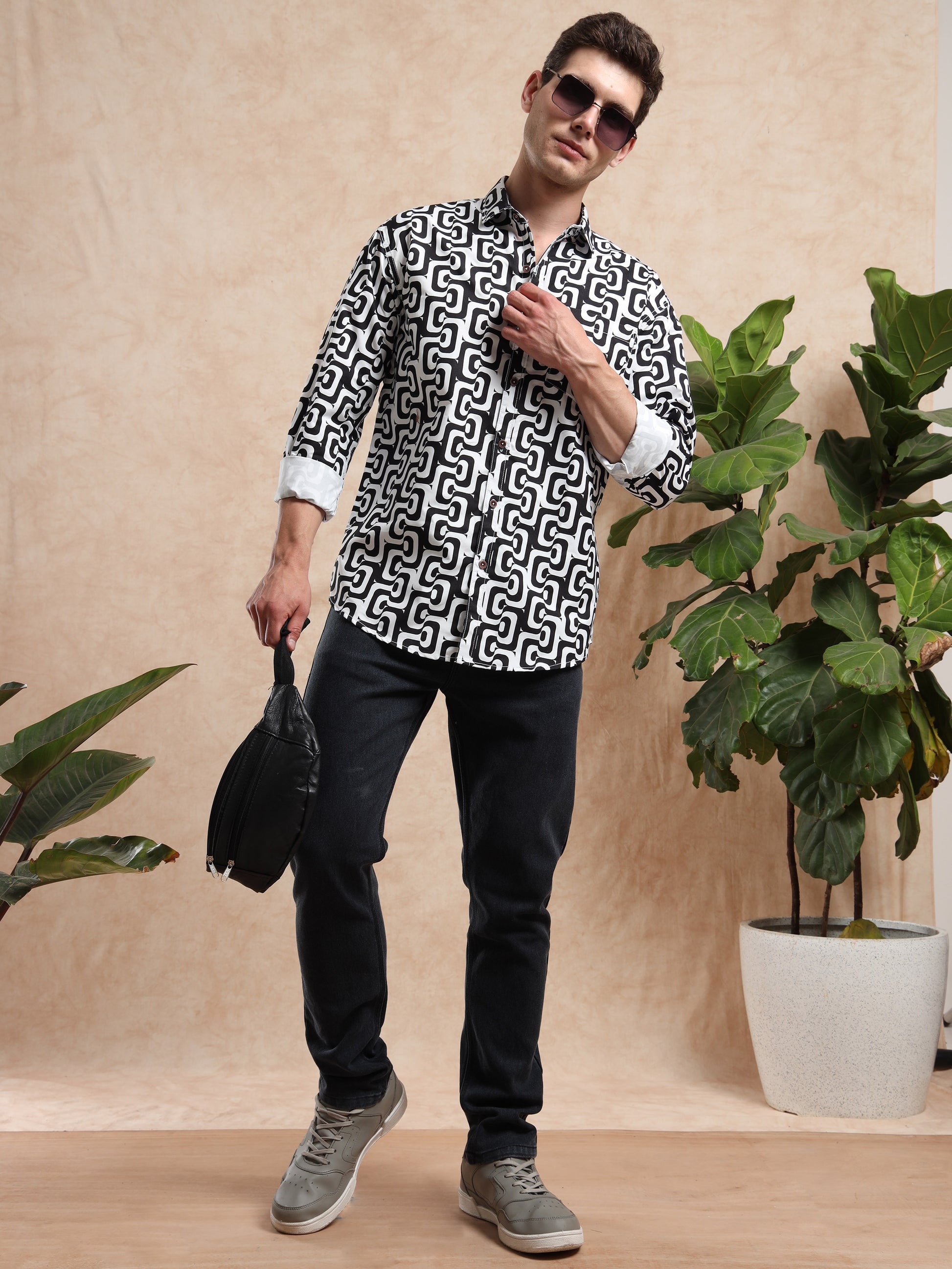 Men, casual outfit with black and white printed shirt styled with black jeans and grey sneakers