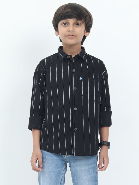 Child wearing a black striped shirt and jeans on a white background