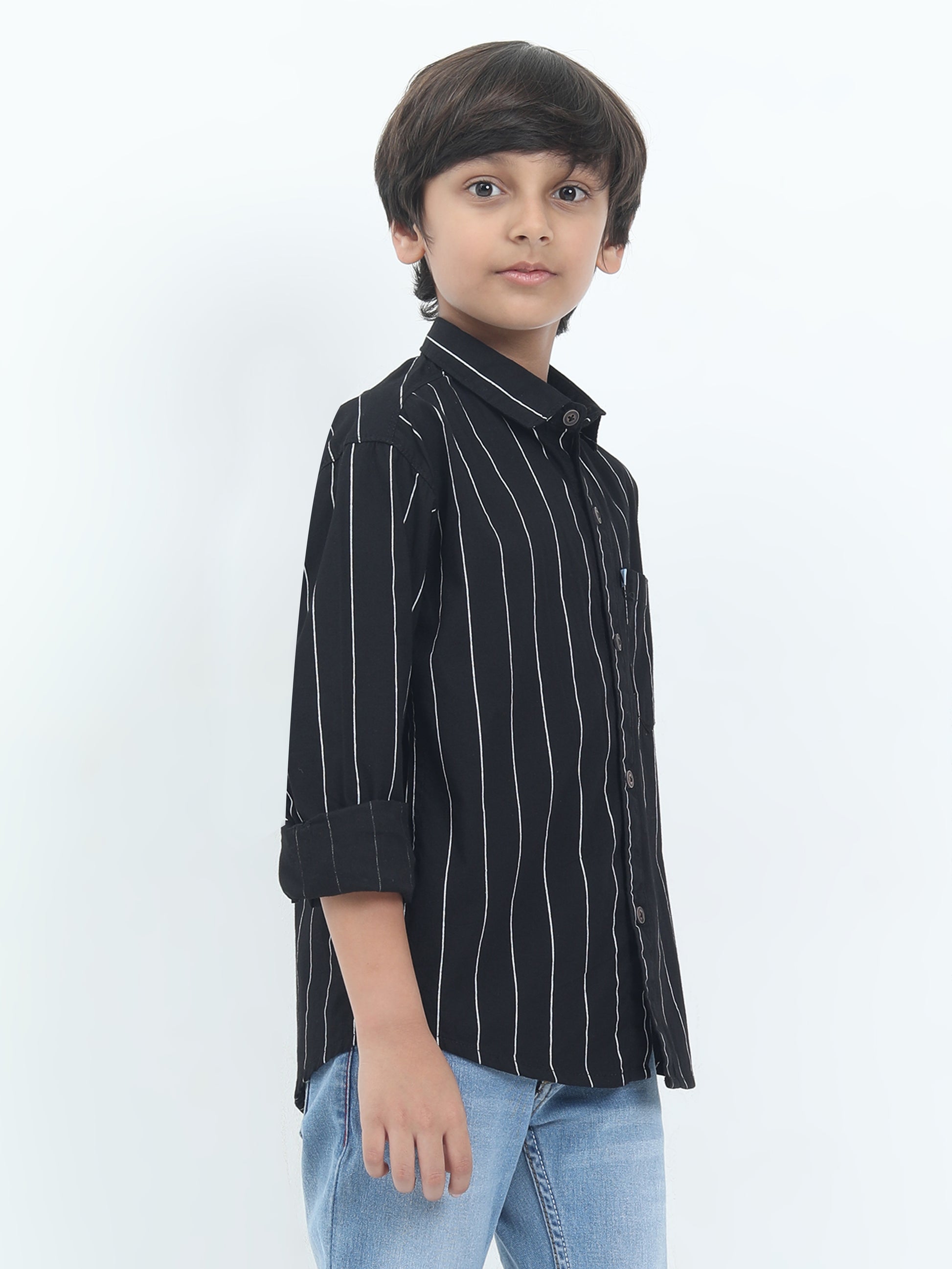 Child wearing a black striped shirt and blue jeans on a white background