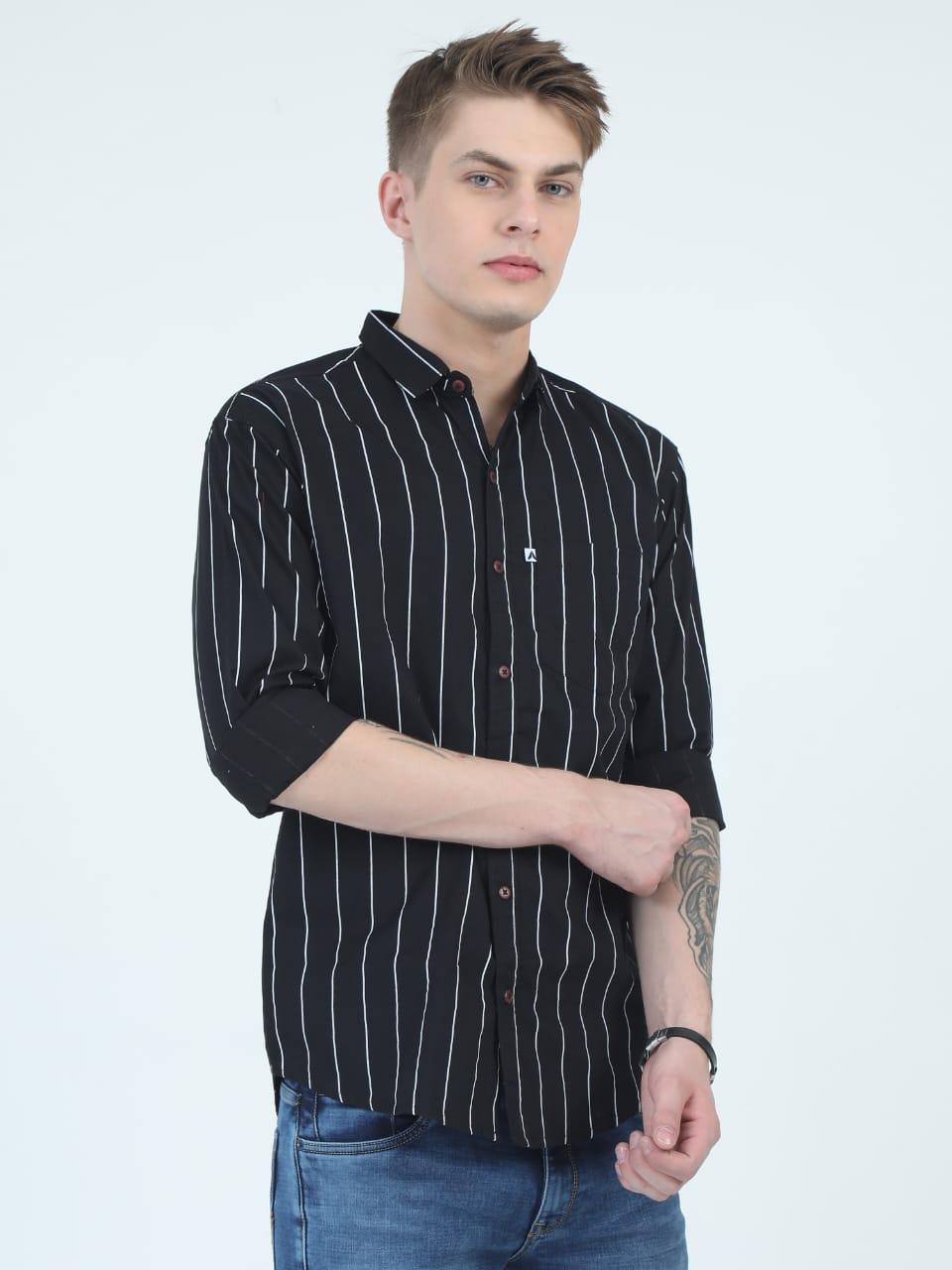 Man wearing a black striped shirt with rolled-up sleeves on a white background