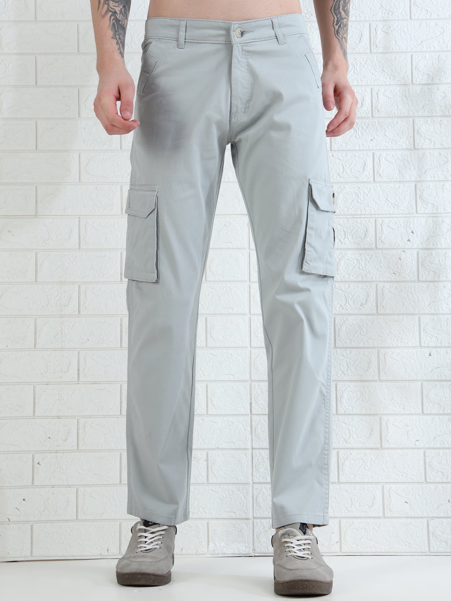 Casual men's grey cargo pants paired with sneakers in studio setup