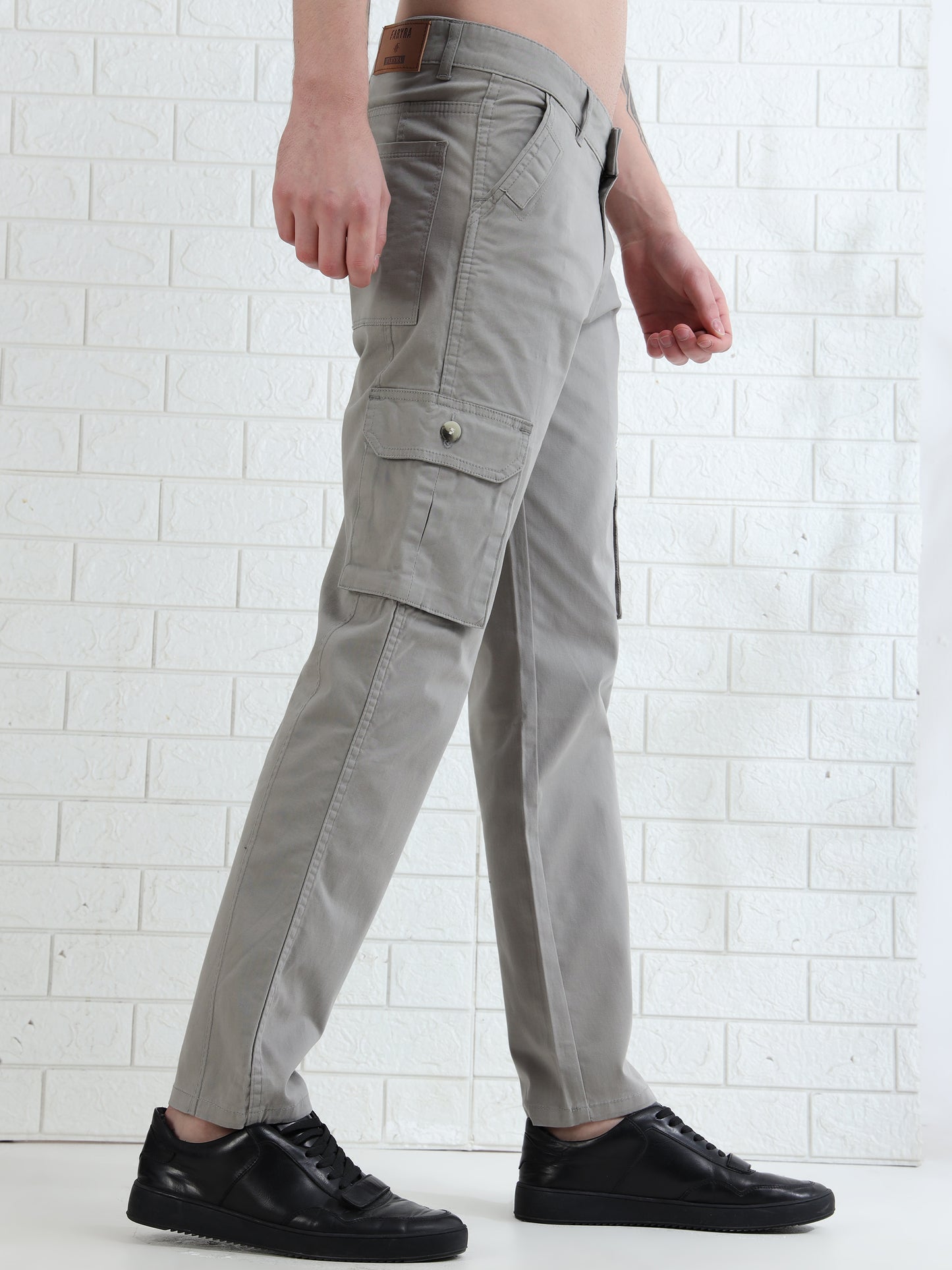 Casual men's beige cargo pants paired with black shoes studio setup