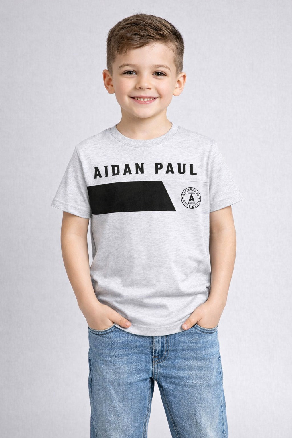 Boys light grey graphic t-shirt paired with blue jeans front pose trendy kids fashion wear.