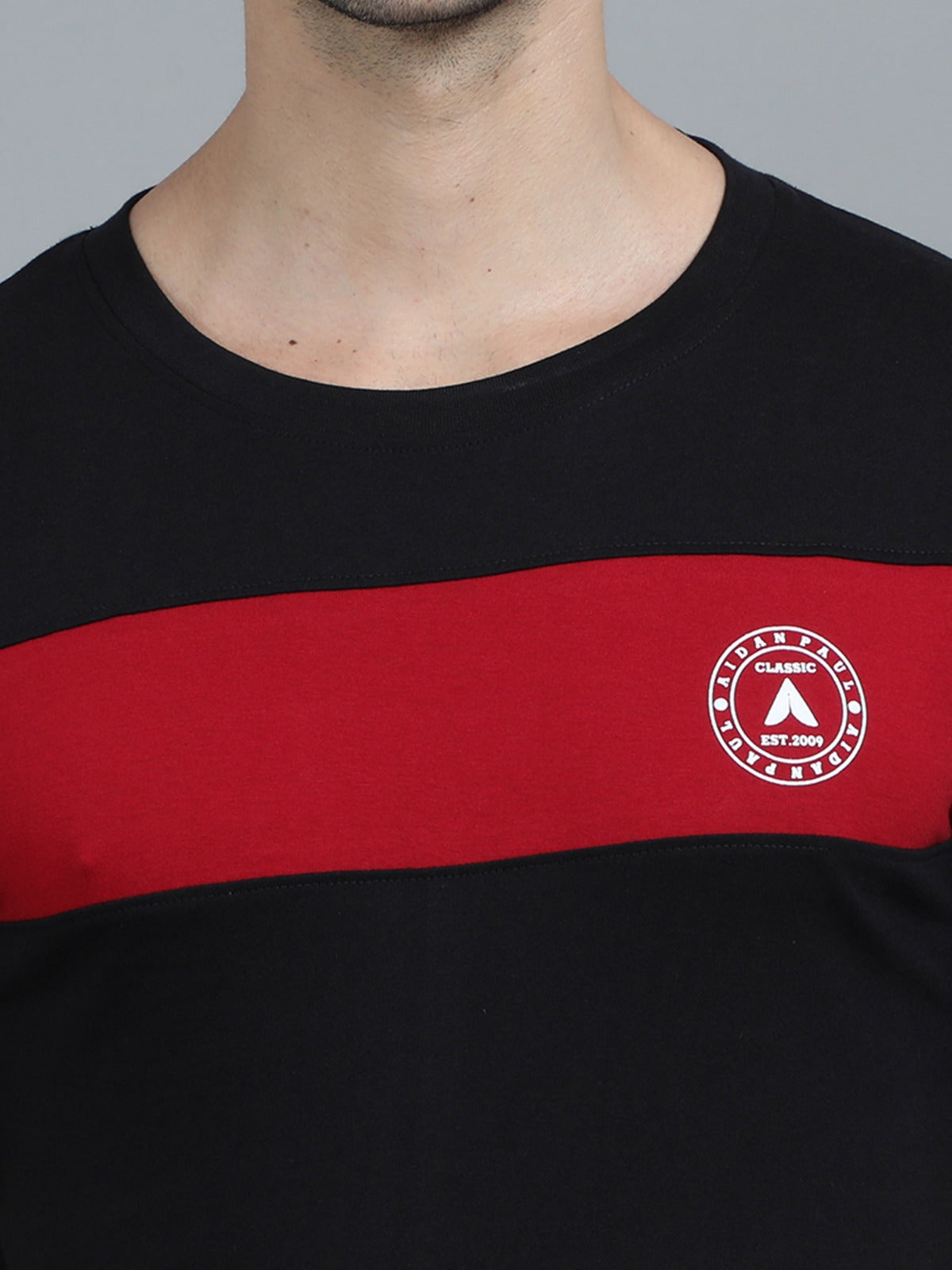 Men's black crew neck t-shirt with red stripe paired with light blue jeans smart everyday fashion wear.