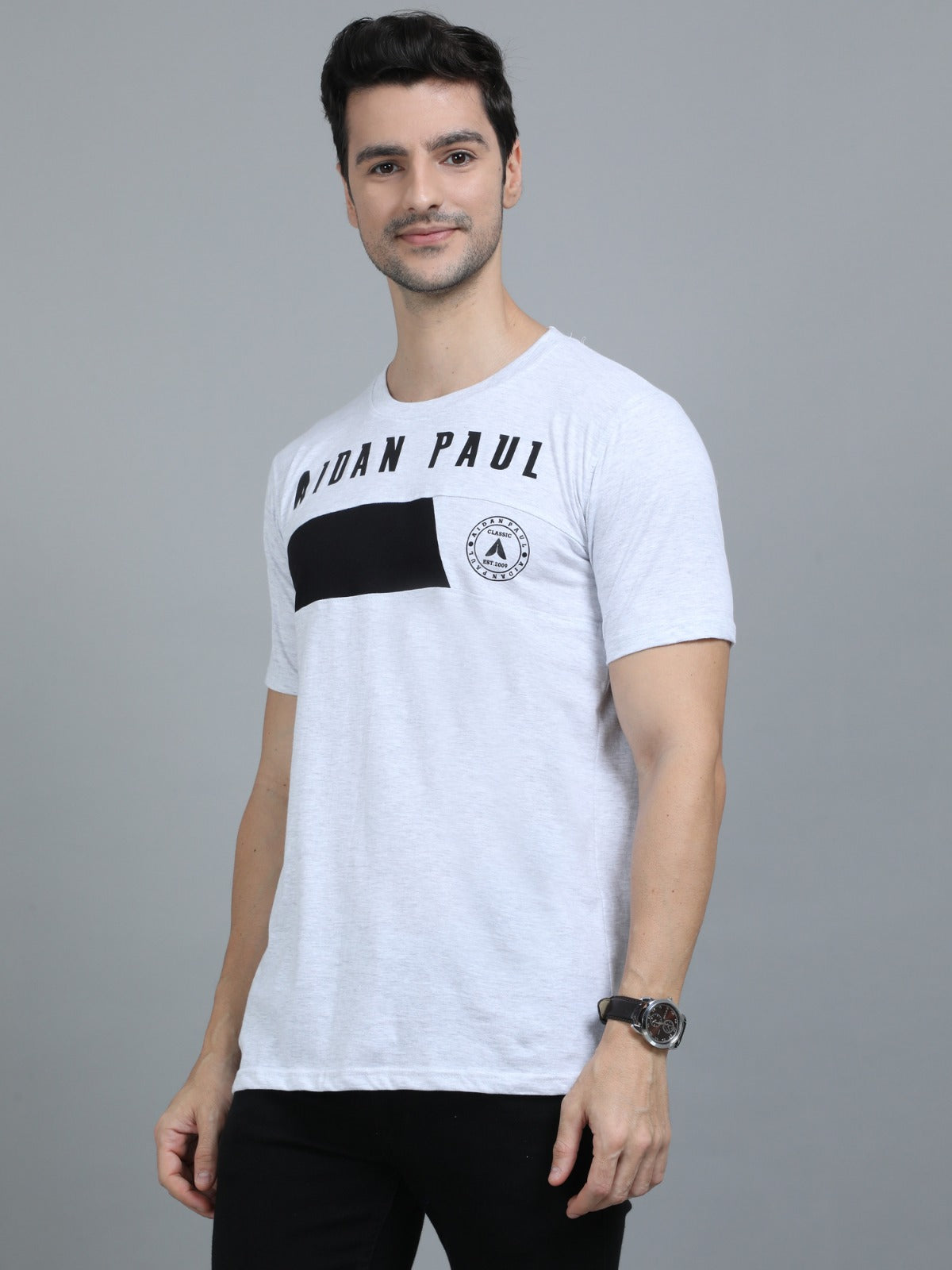 Men's white crew neck t-shirt with front print paired with black jeans smart everyday fashion wear.