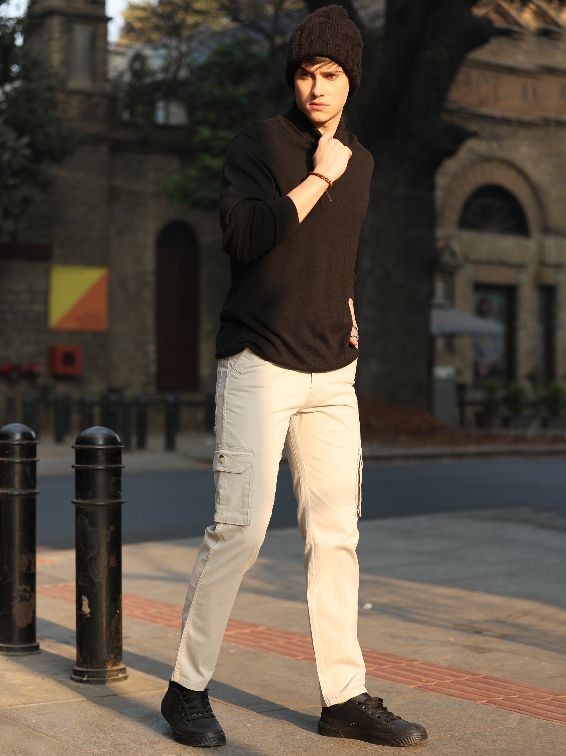 Casual men's cream cargo pants paired with sneakers