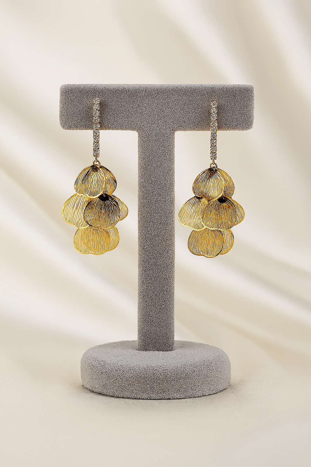 Elegant gold petal drop earrings featuring layered floral dangles and crystal-stone hooks