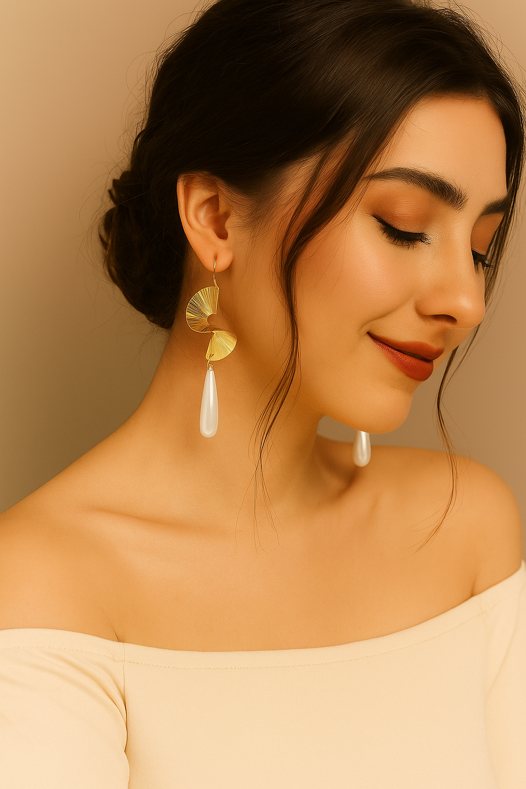 Woman wearing gold and white earrings against a beige background