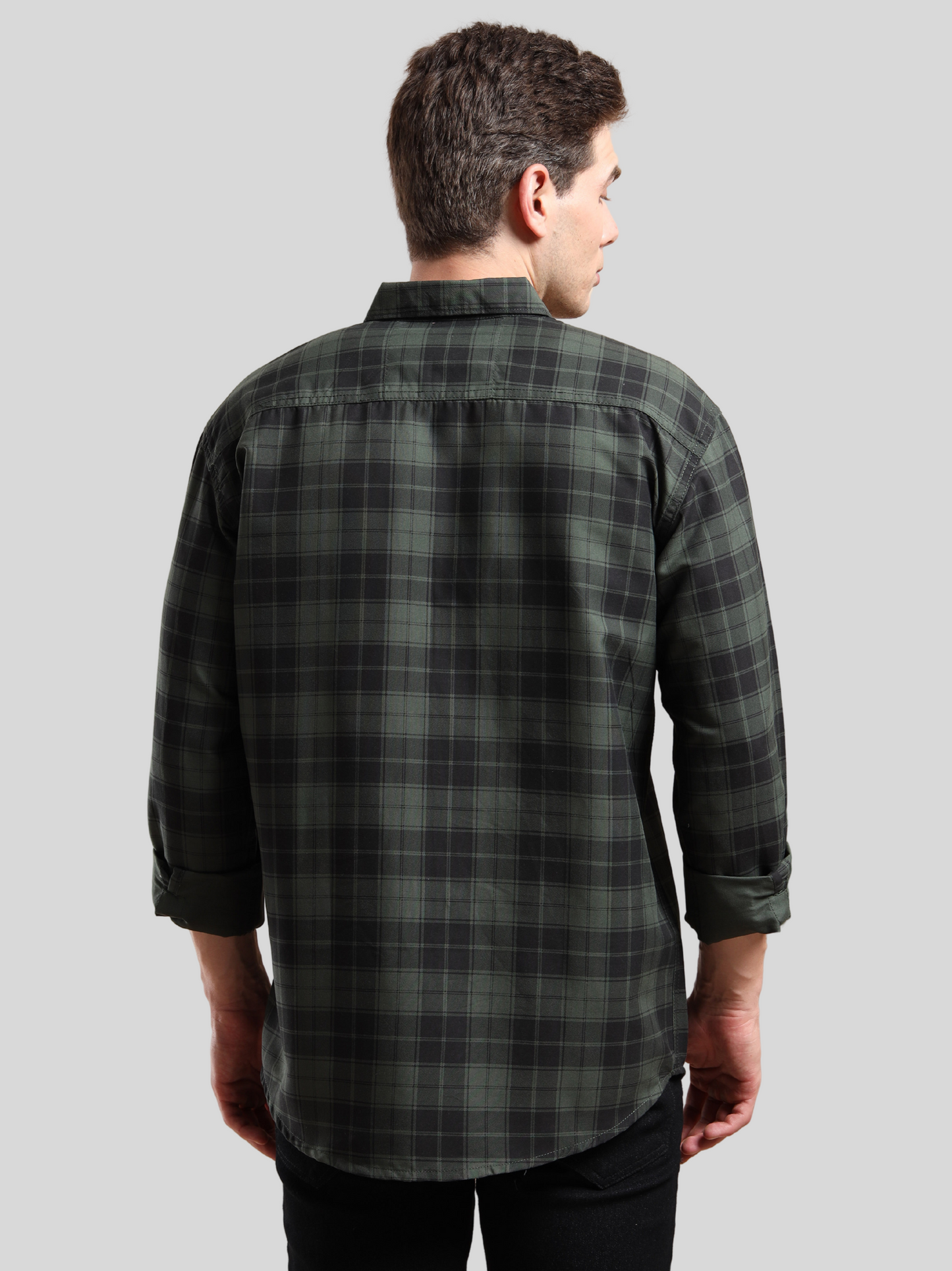 Stylish men, green plaid shirt paired with black jeans, casual wear look.