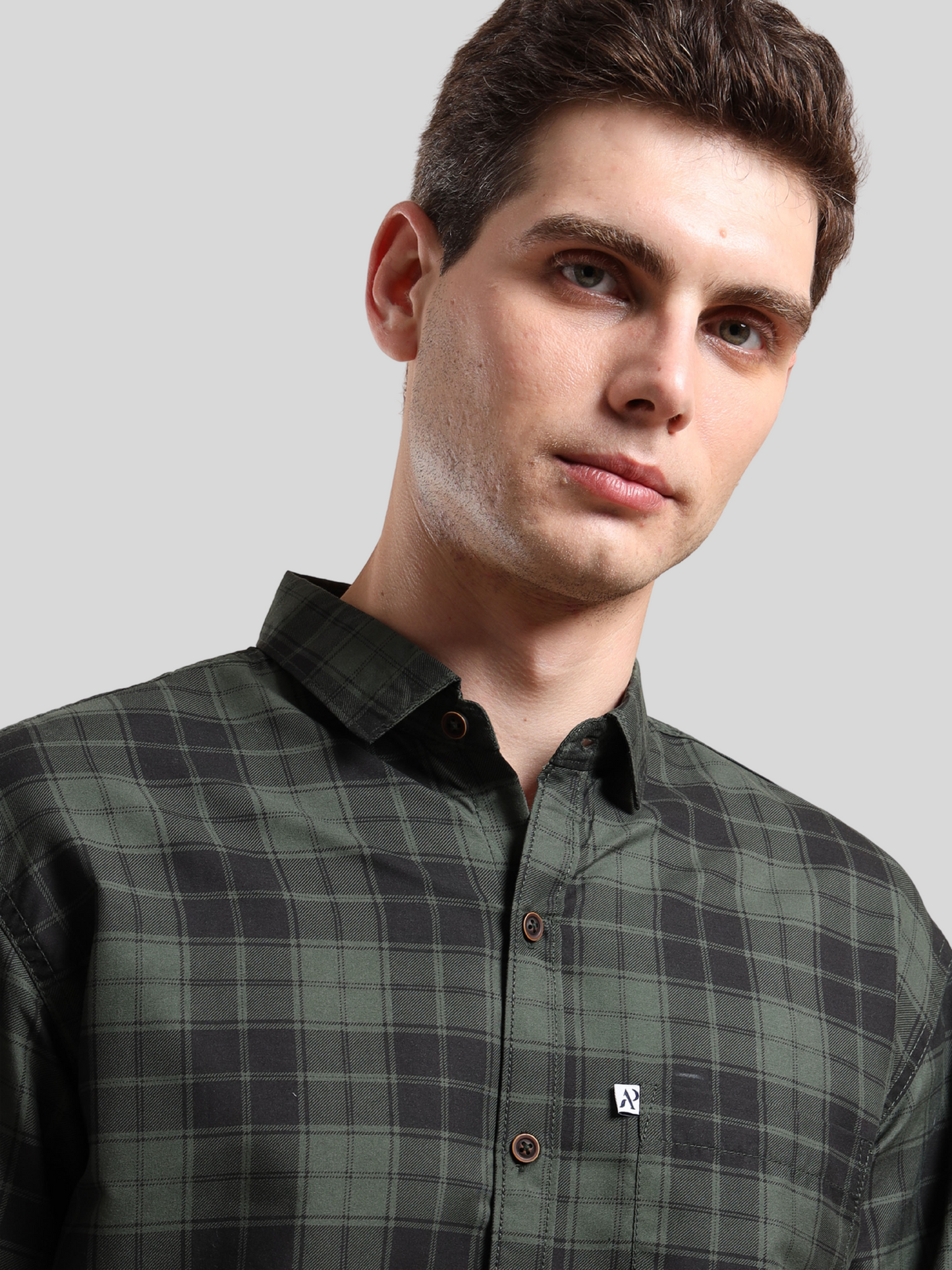 green and black checkered shirt, buttoned-up collar.