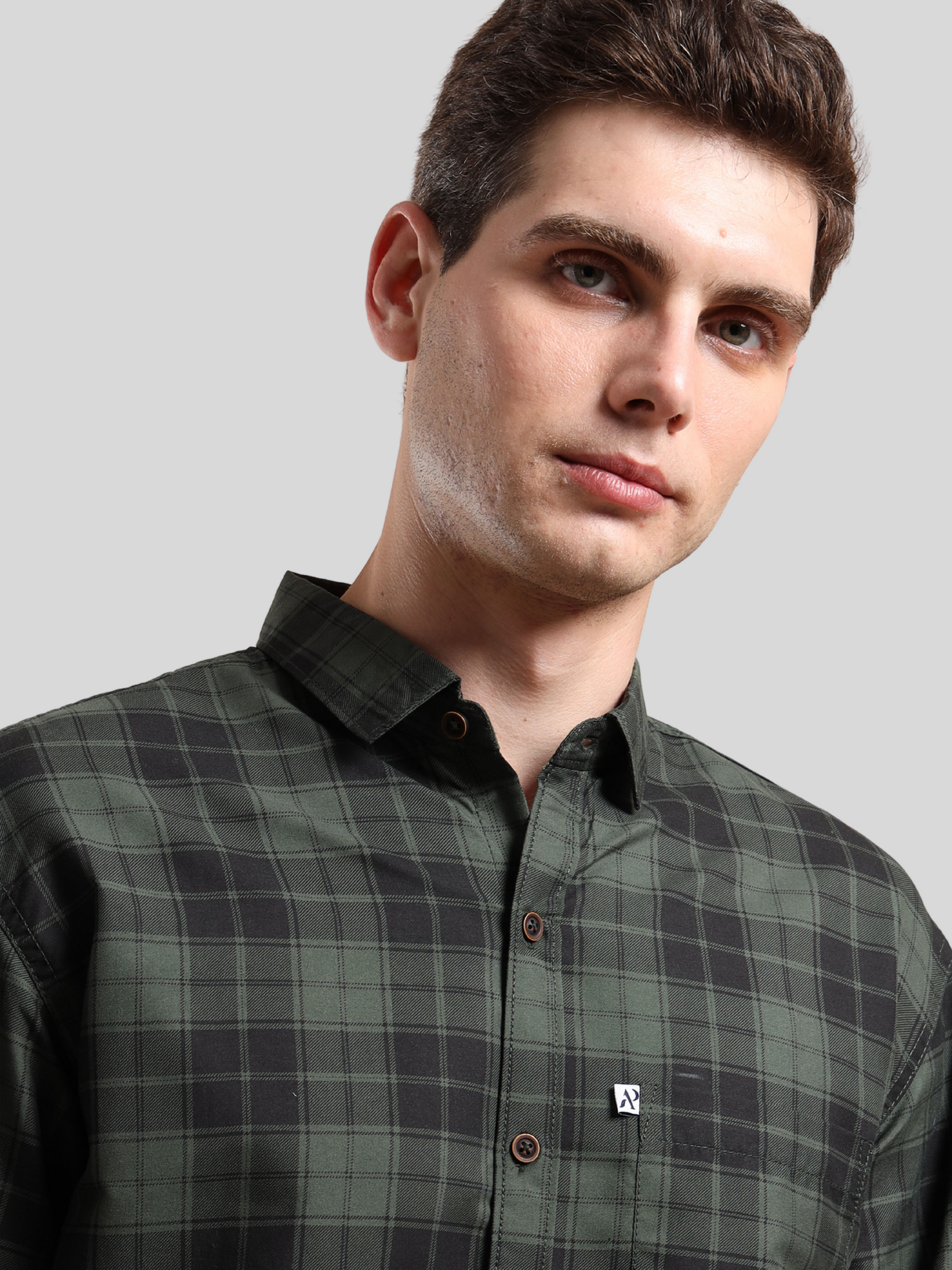 green and black checkered shirt, buttoned-up collar.
