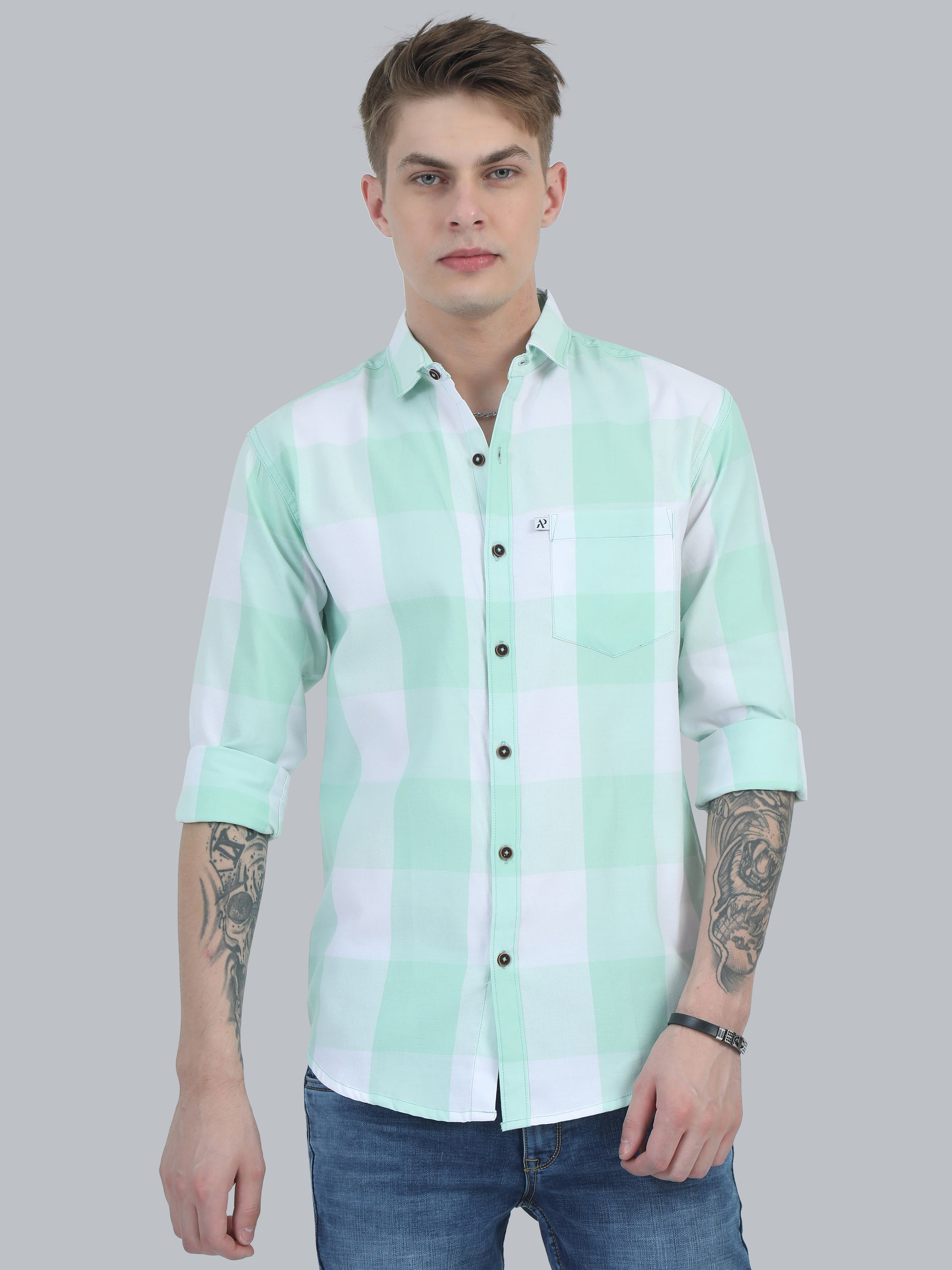 A man wearing a light green checkered shirt with full sleeves and a regular collar.