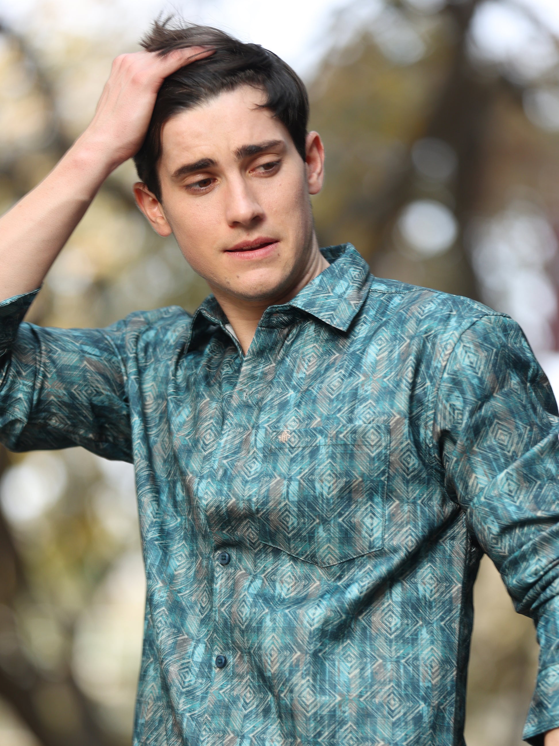 Stylish man wearing green patterned casual shirt with button-down front