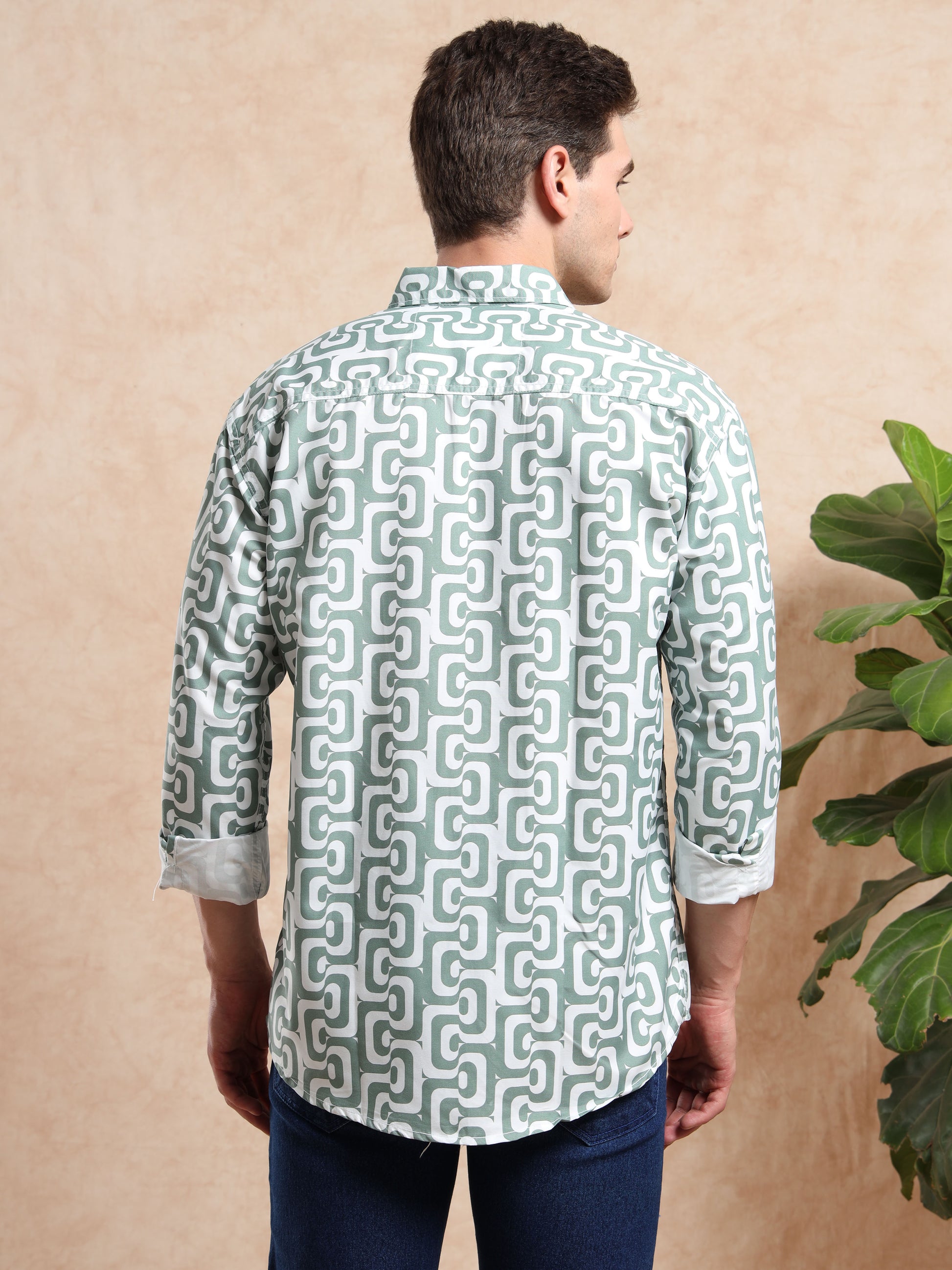 Back view of men, green geometric print shirt with folded sleeves.