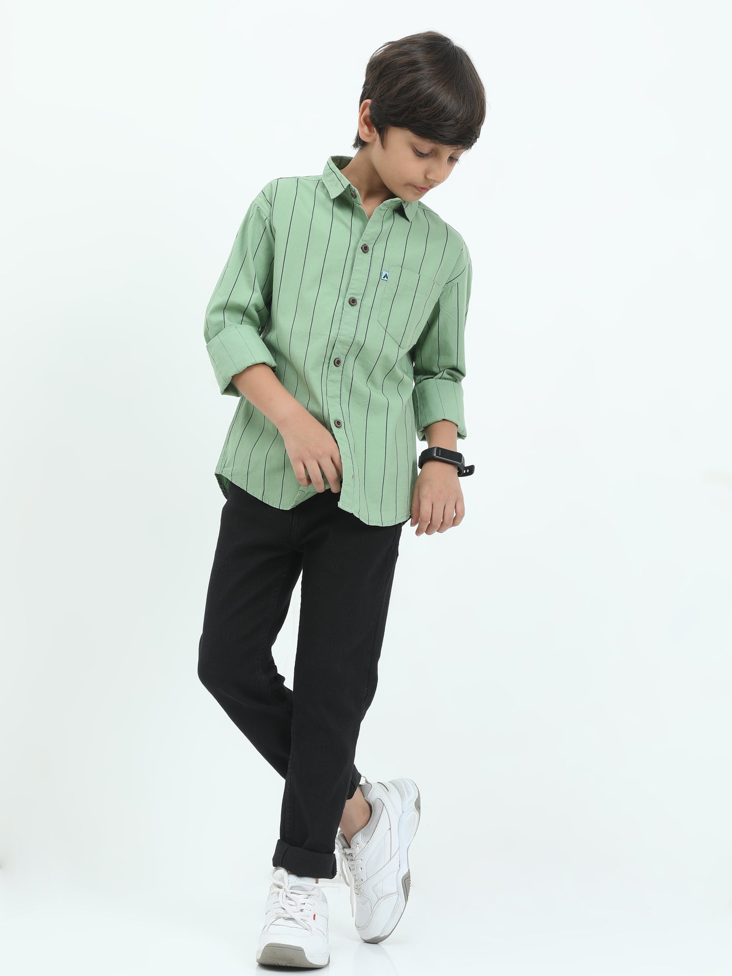 Child wearing a green striped shirt and black pants on a white background