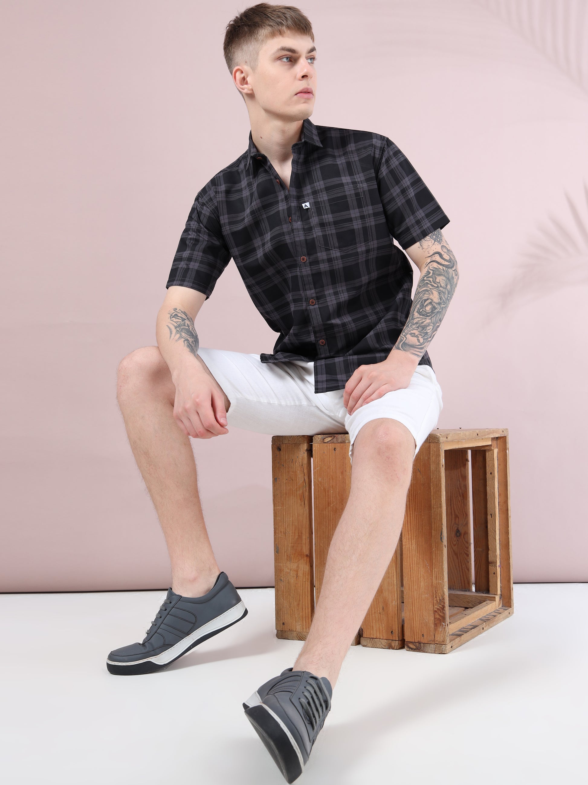 Men, fashion look, black checked shirt styled with white shorts and grey sneakers.