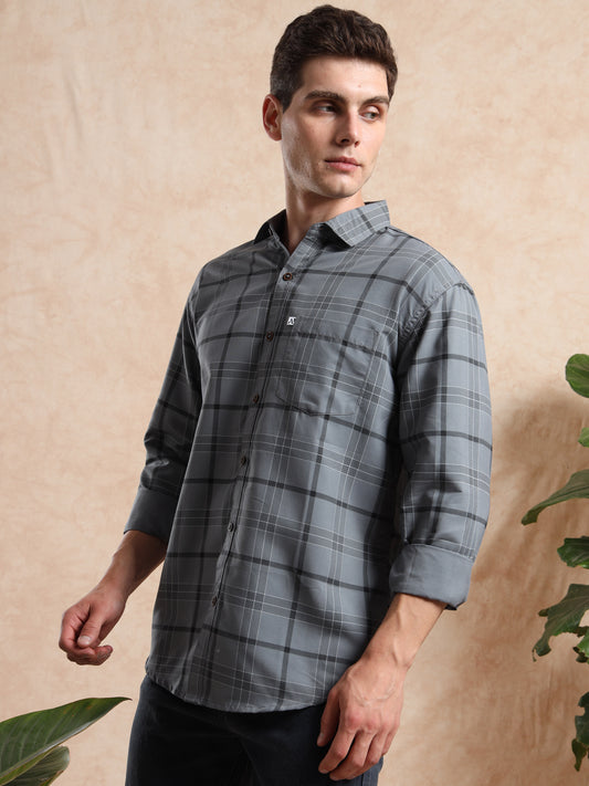 grey checkered casual shirt with full sleeves, styled with dark denim jeans.