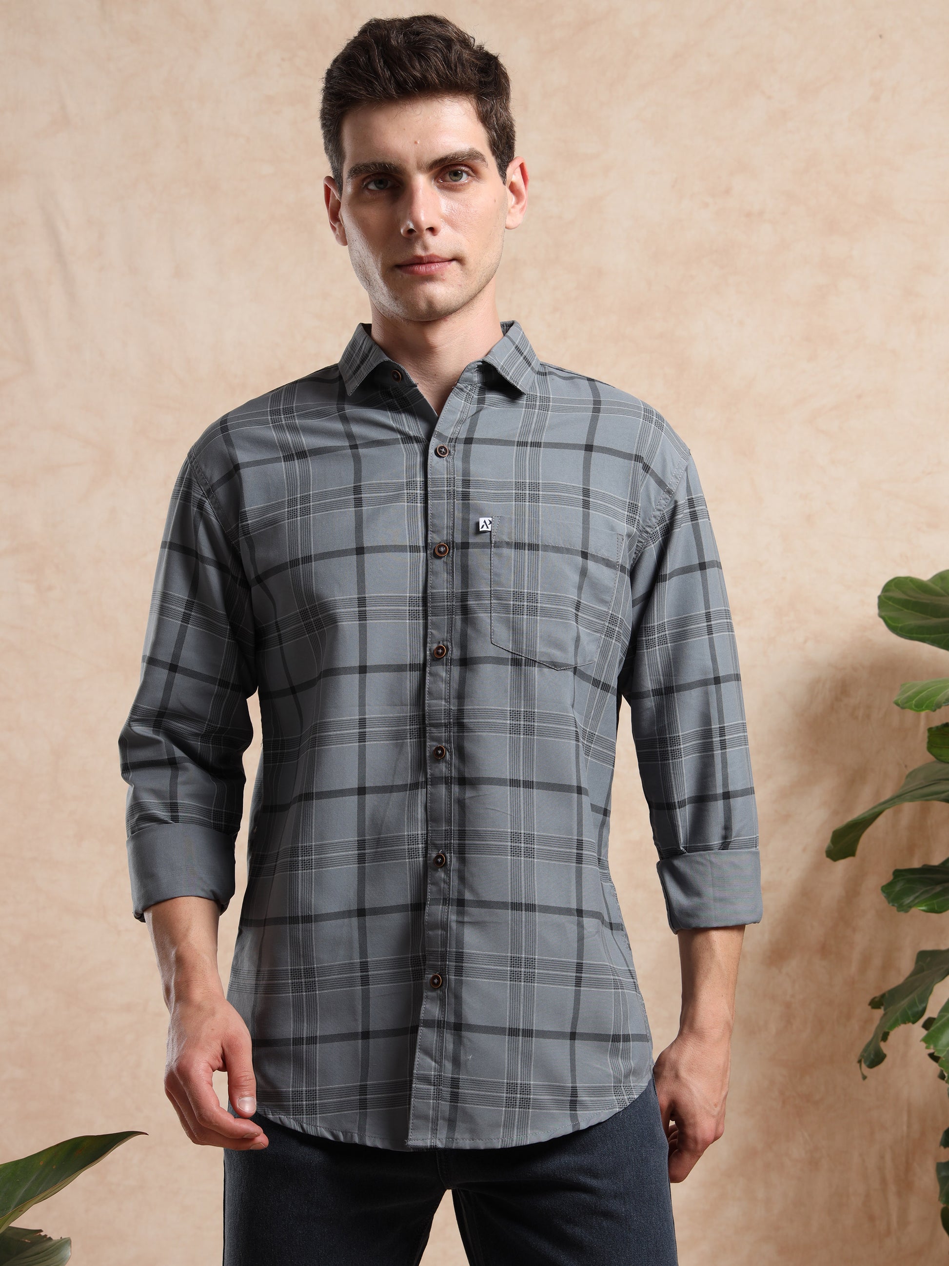 grey checked shirt paired with black jeans.
