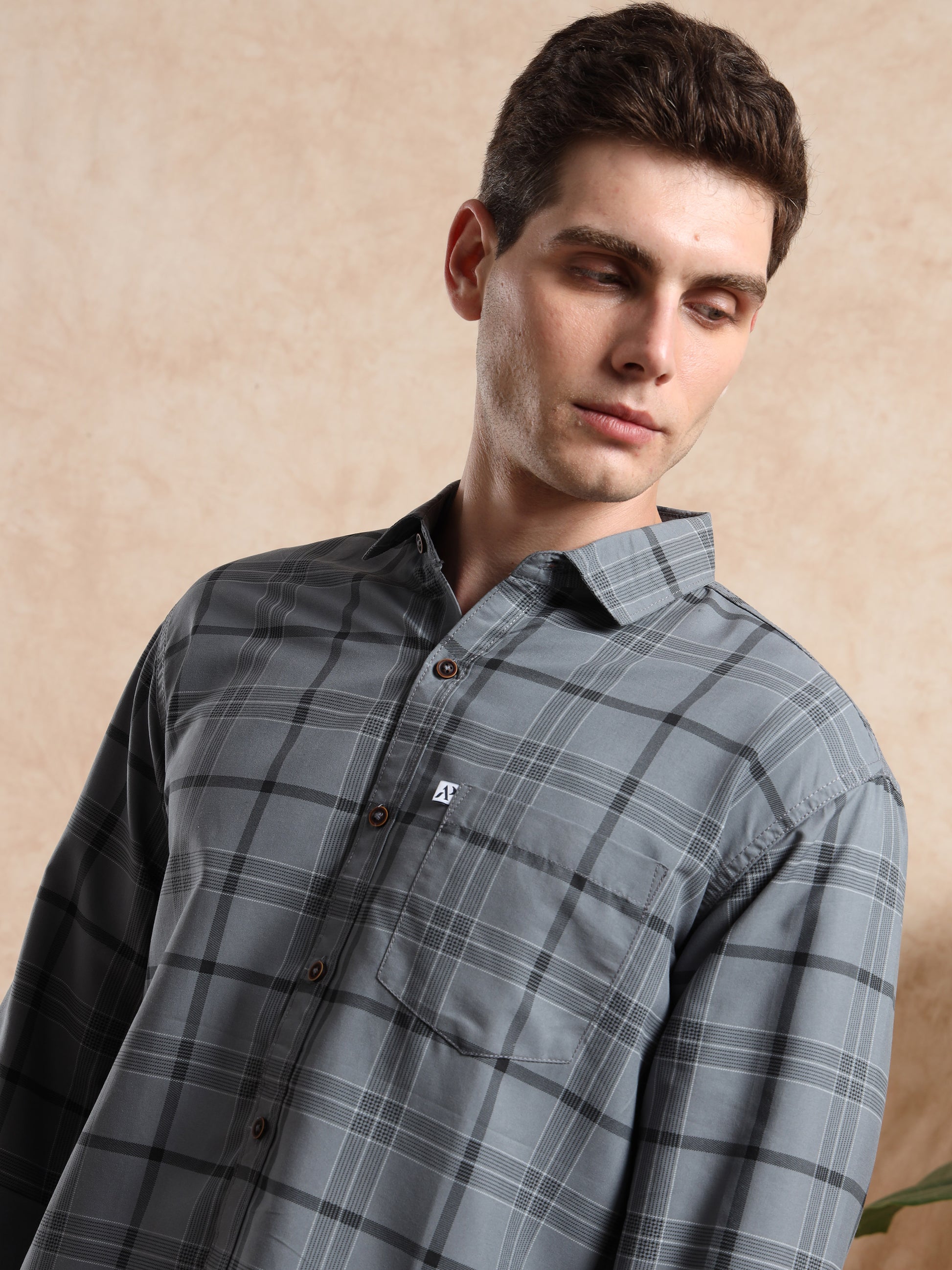 chest pocket and button detailing on ash grey checkered shirt.