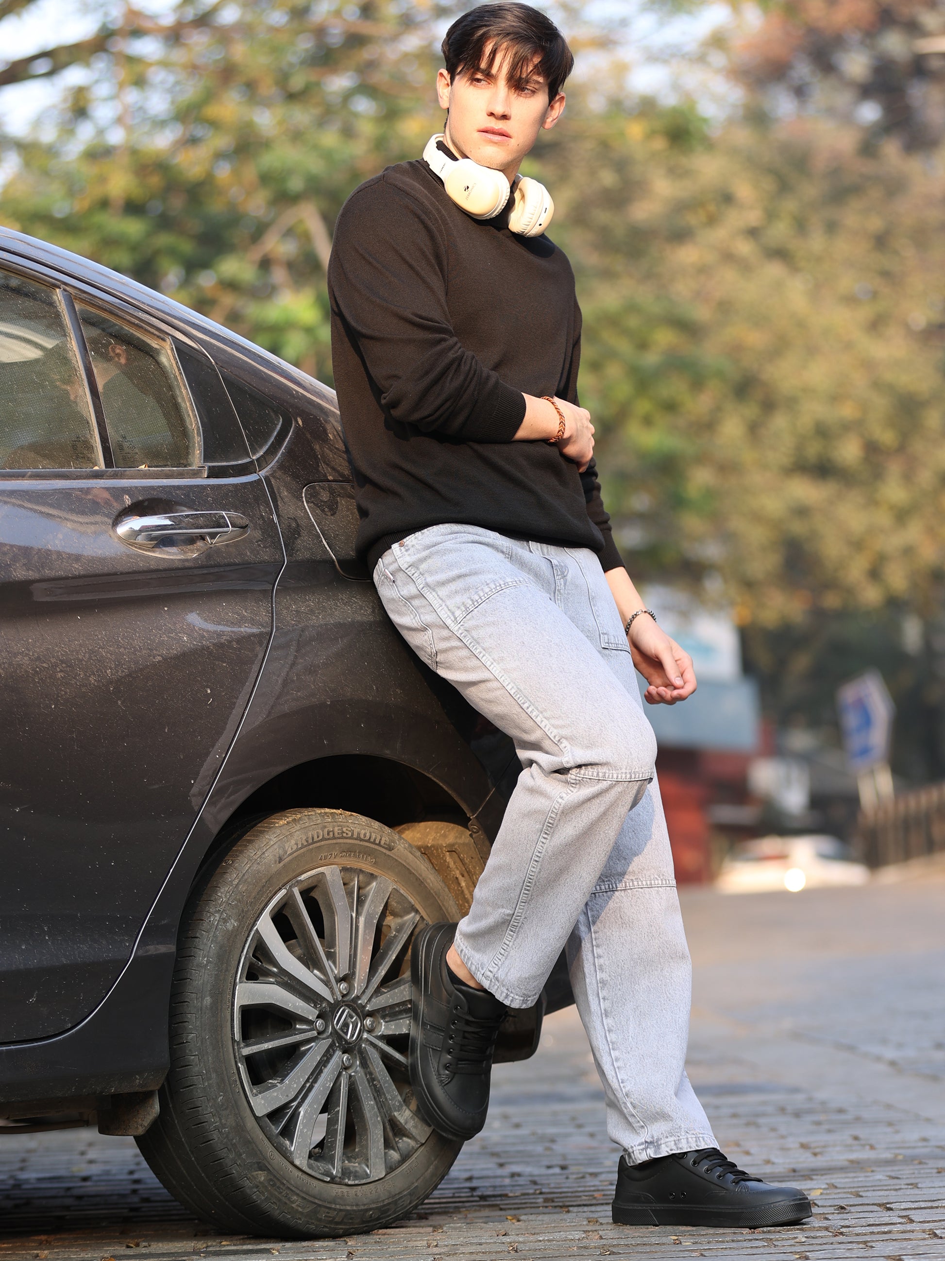 Casual men's light grey jeans paired with white sneakers studio look