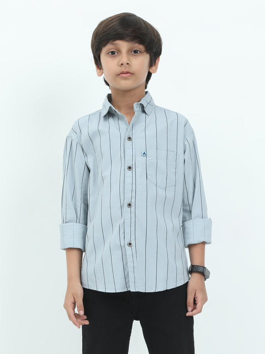Child wearing a light blue striped shirt on a white background