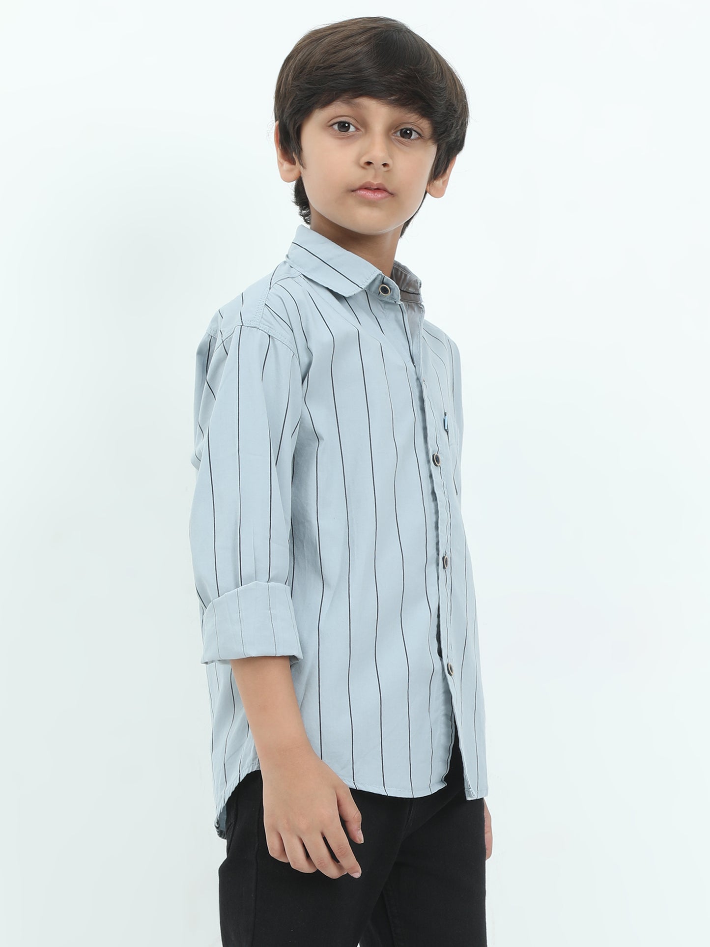 Young boy wearing a light blue striped shirt on a white background