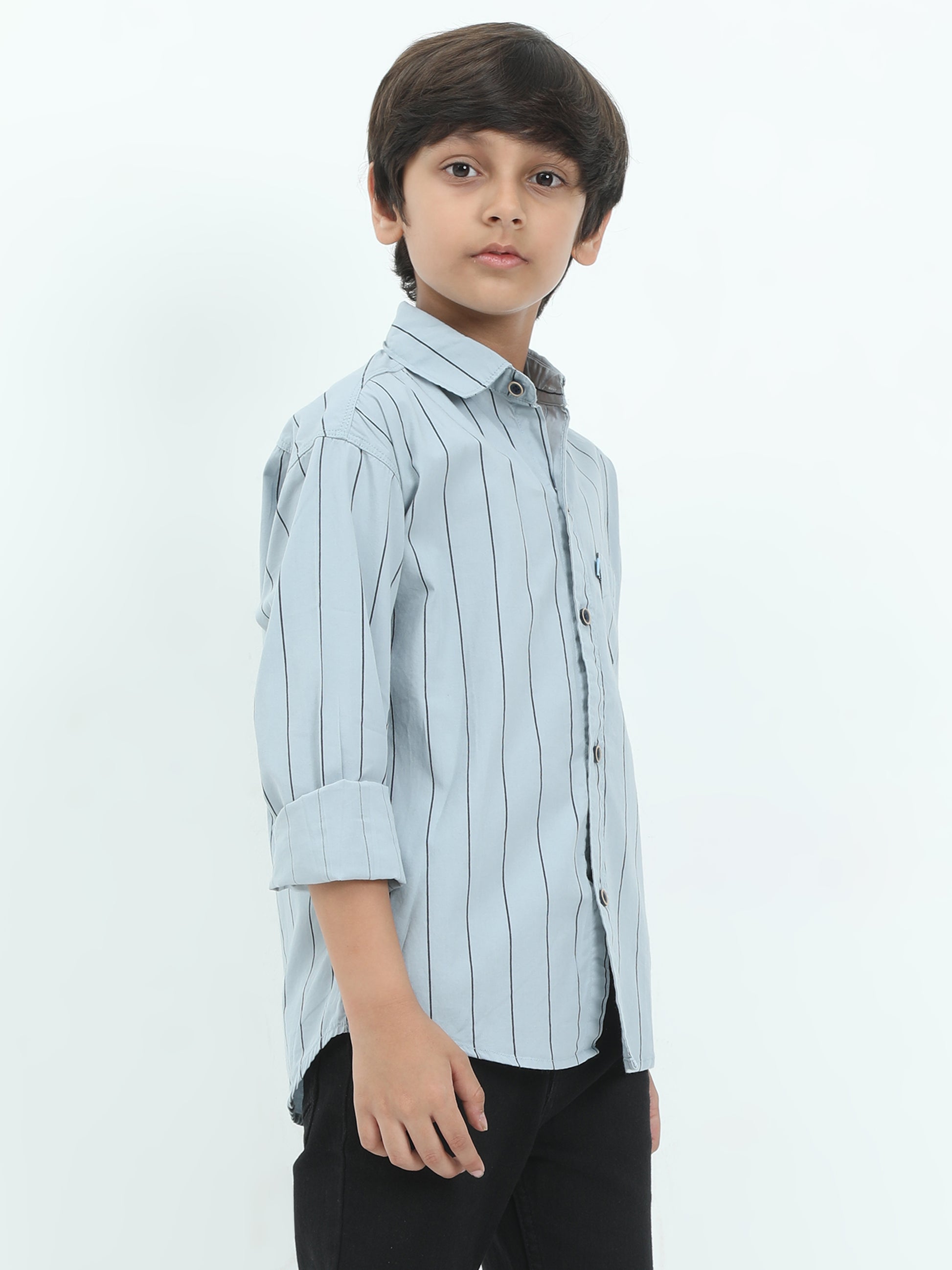 Young boy wearing a light blue striped shirt on a white background