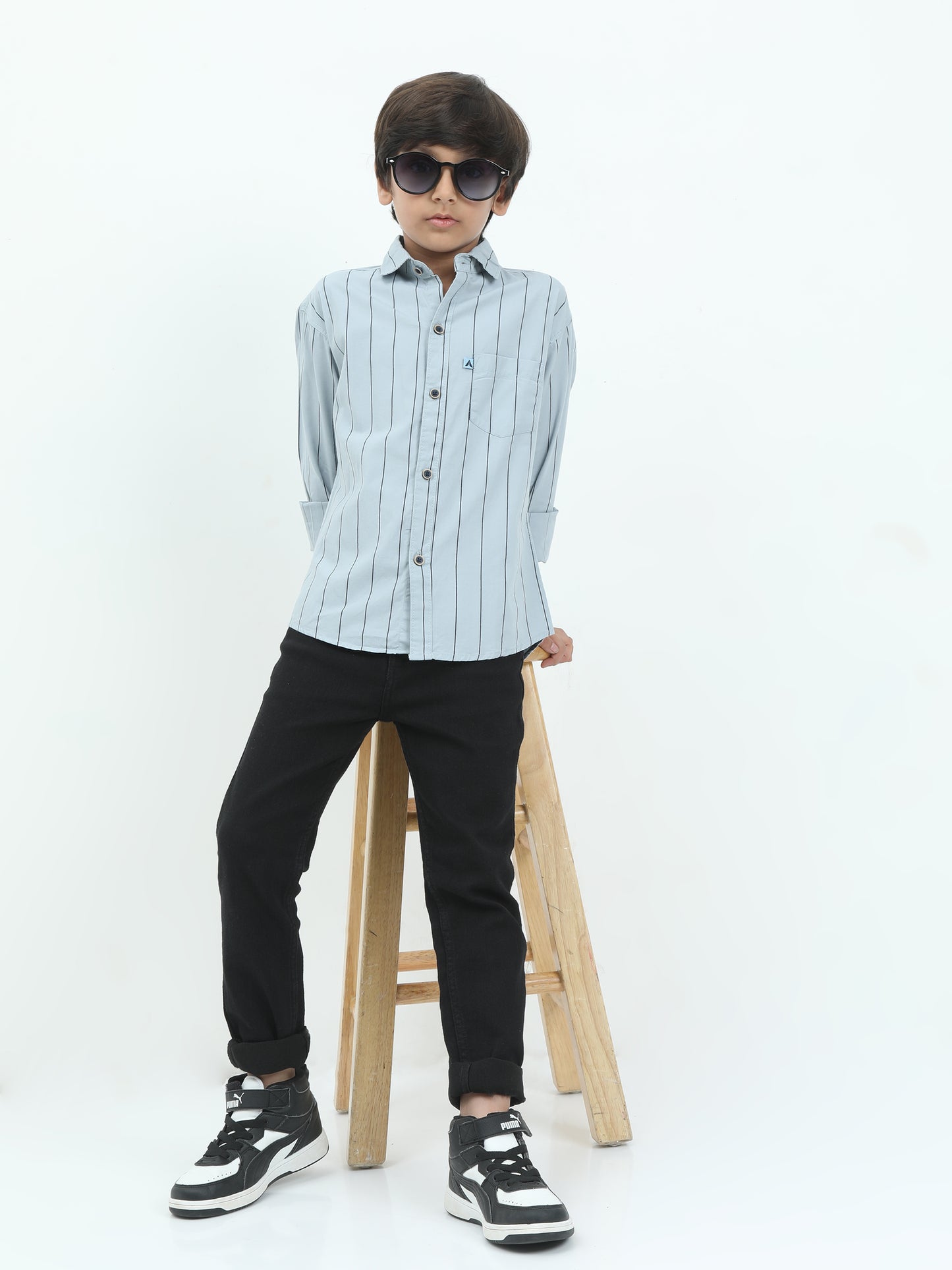 Person wearing a light blue striped shirt and black pants on a white background