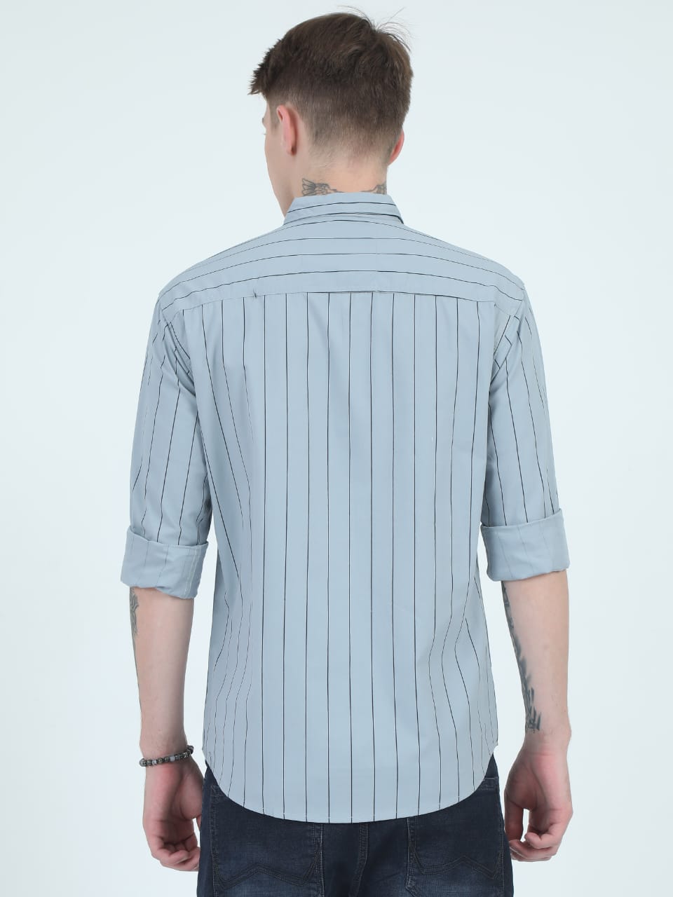 Man wearing a light blue striped shirt on a white background