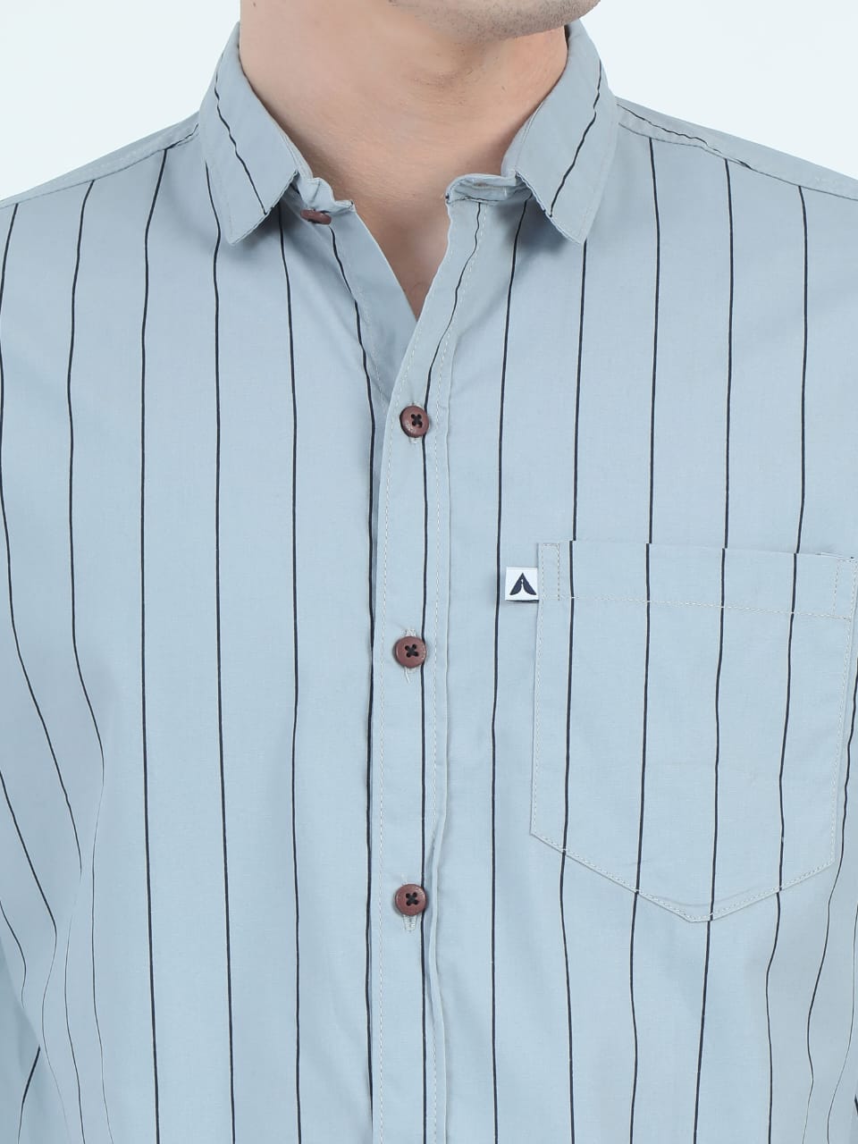 Light blue striped shirt with a small logo on a white background