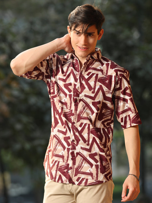 A man wearing a maroon and white geometric patterned, half-sleeved shirt with a regular fit.