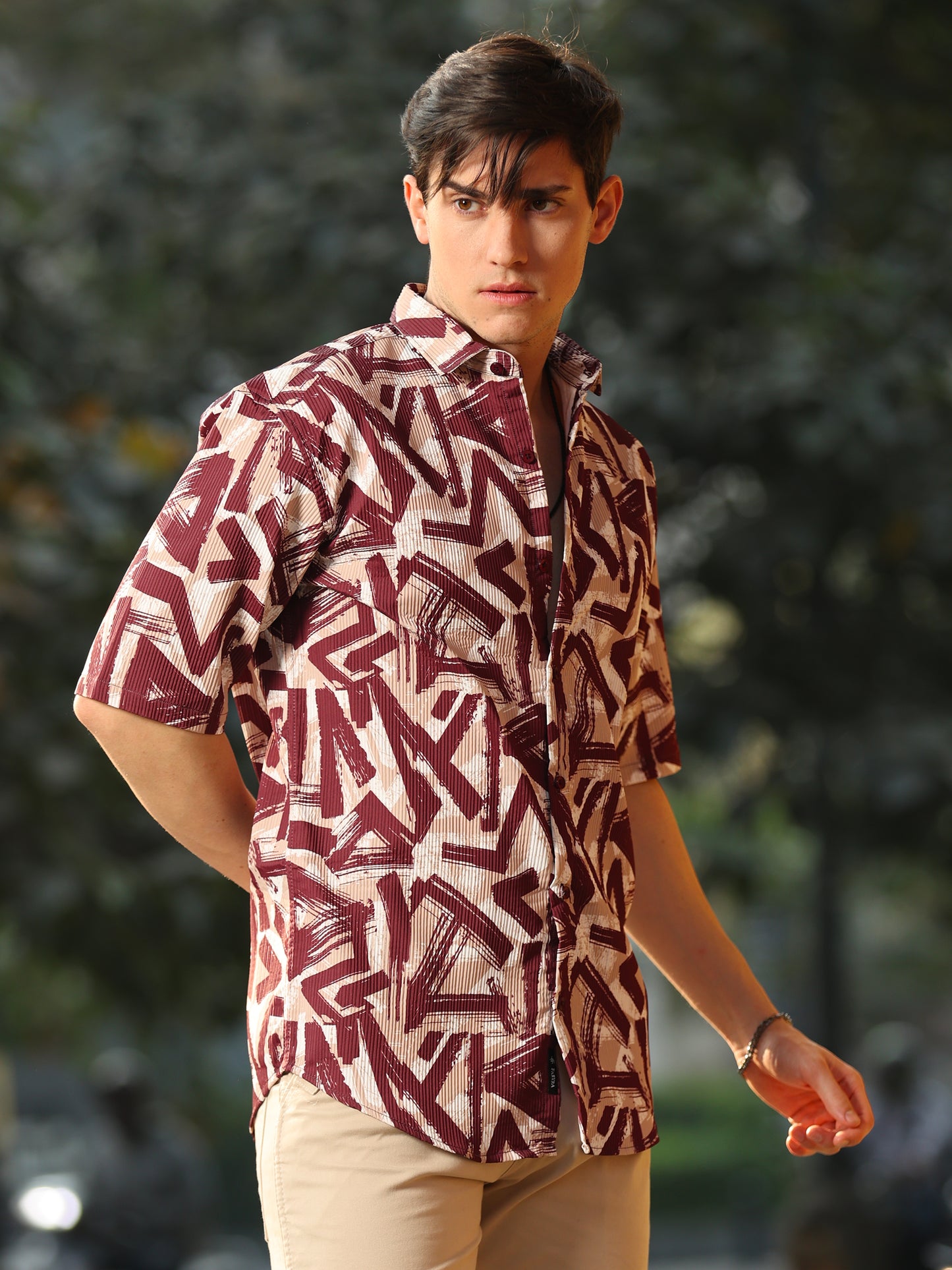 Casual men's printed shirt paired with beige pants in outdoor setting