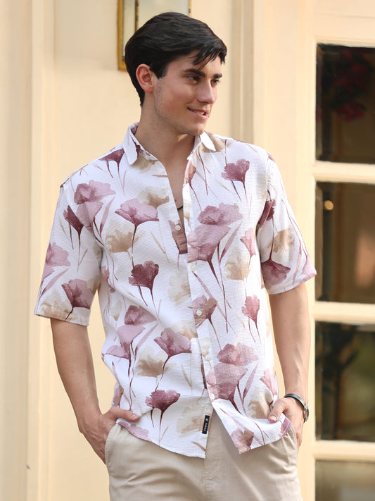 A man wearing a white half-sleeved shirt with a peach dobby print, featuring a regular collar and button-up front.