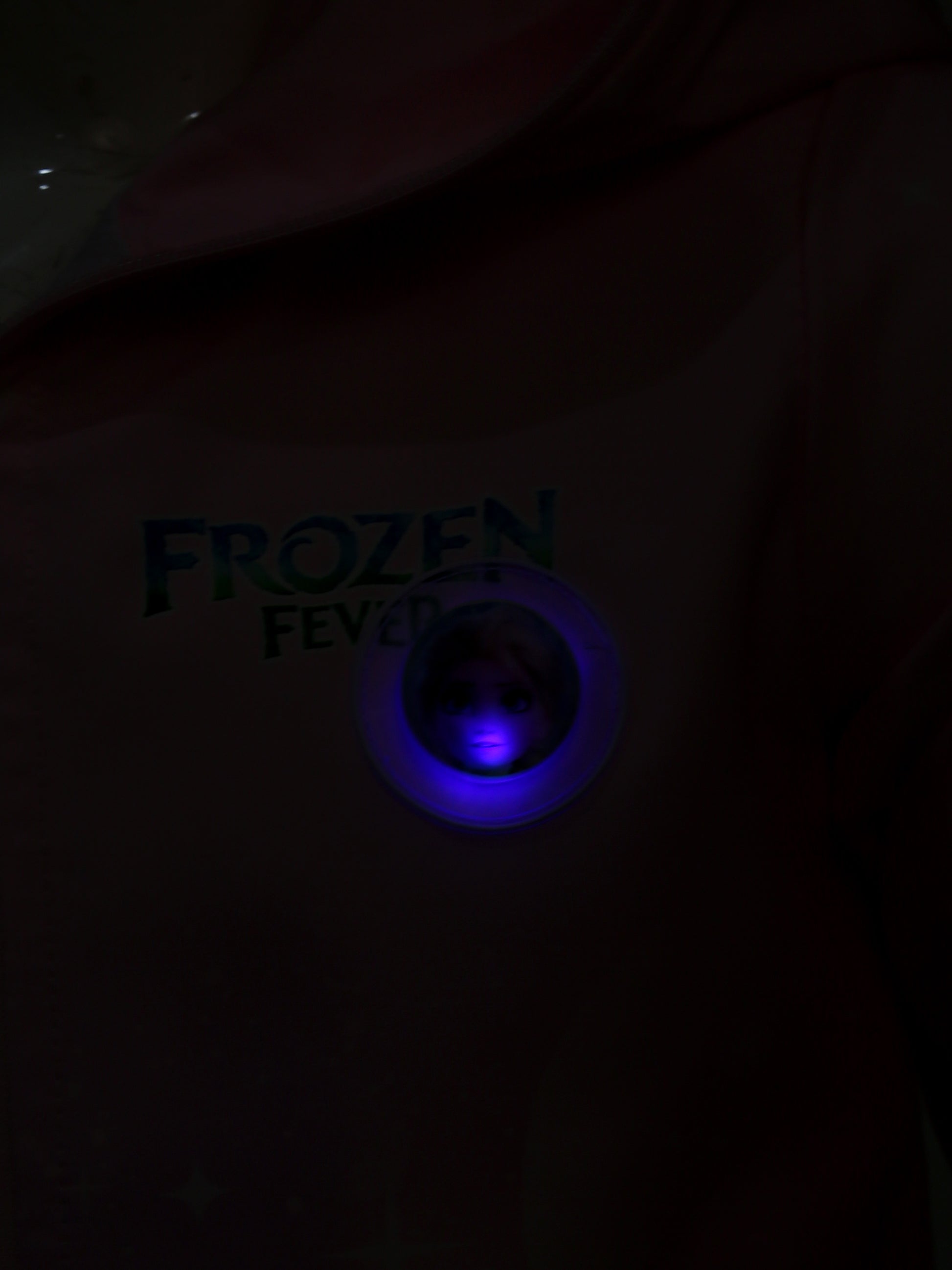Dark shirt with 'Frozen Fever' text and blue light in the center