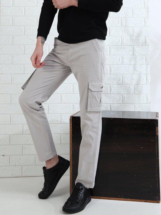 A person standing beside a black box wearing light grey cargo pants with multiple pockets and a button-closure waistband.
