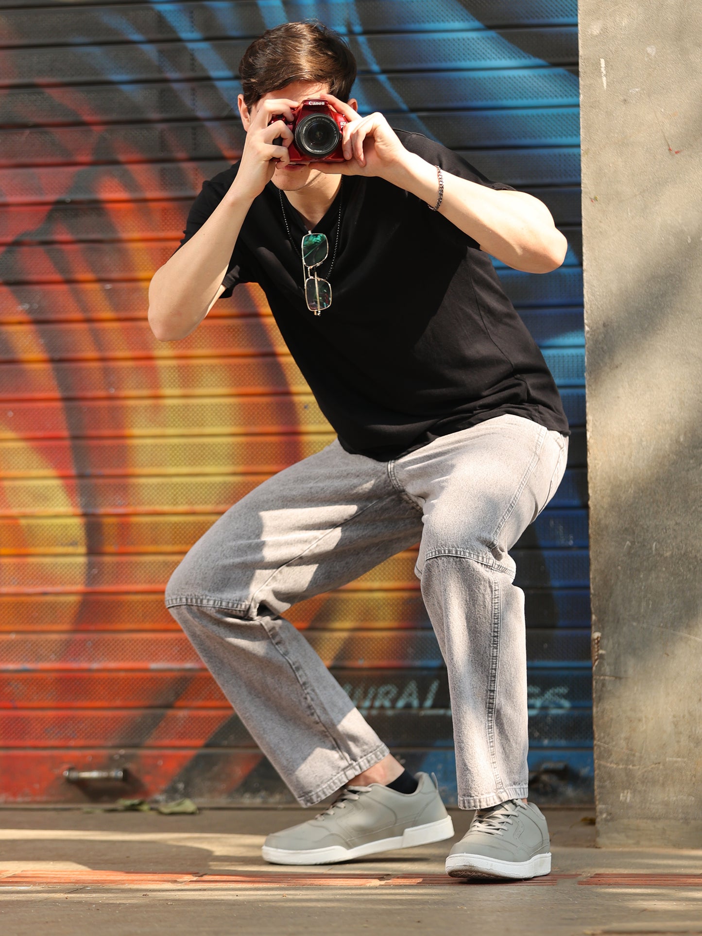 Casual men's light grey jeans paired with white sneakers studio look