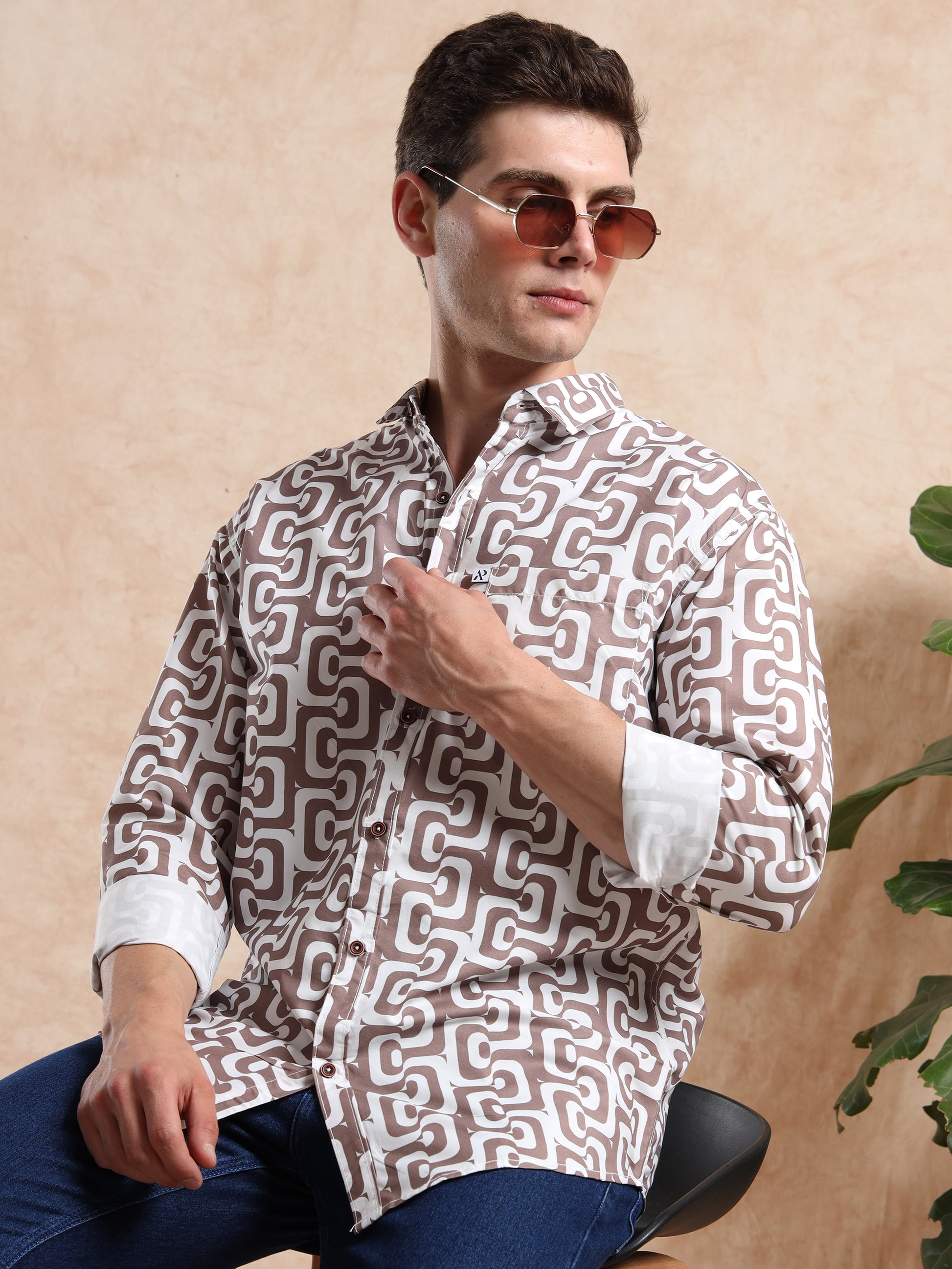 Modern men, printed shirt in brown tones, styled with round sunglasses for a trendy look.