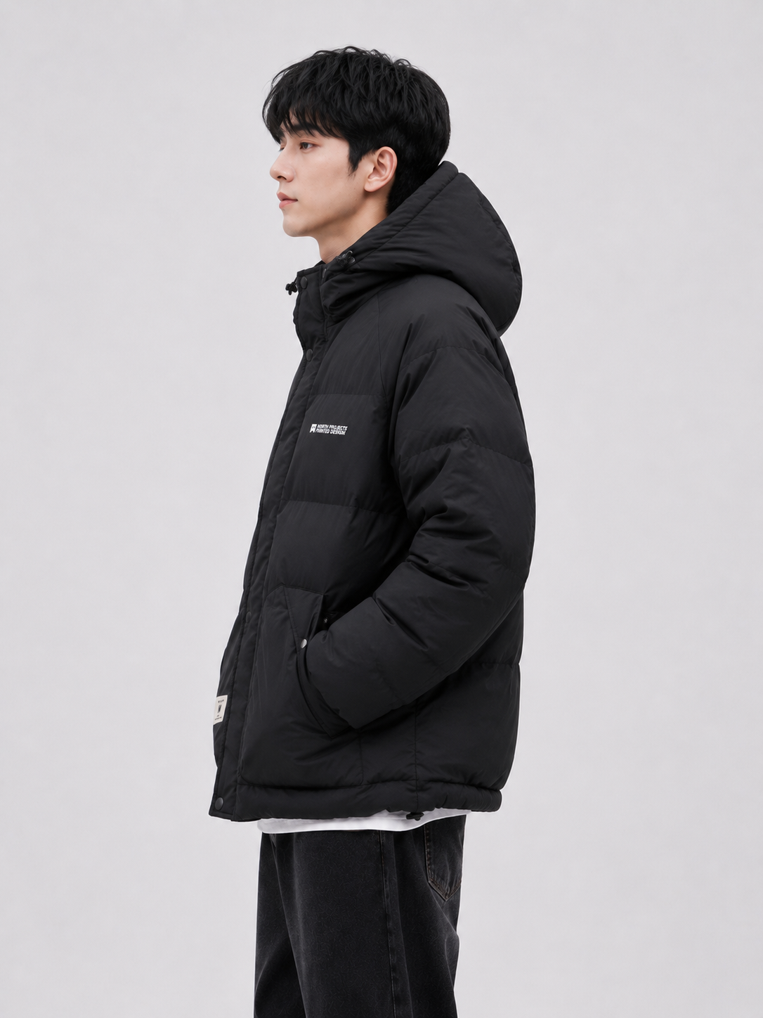 a men's black insulated puffer jacket with a padded hood, high collar, relaxed fit