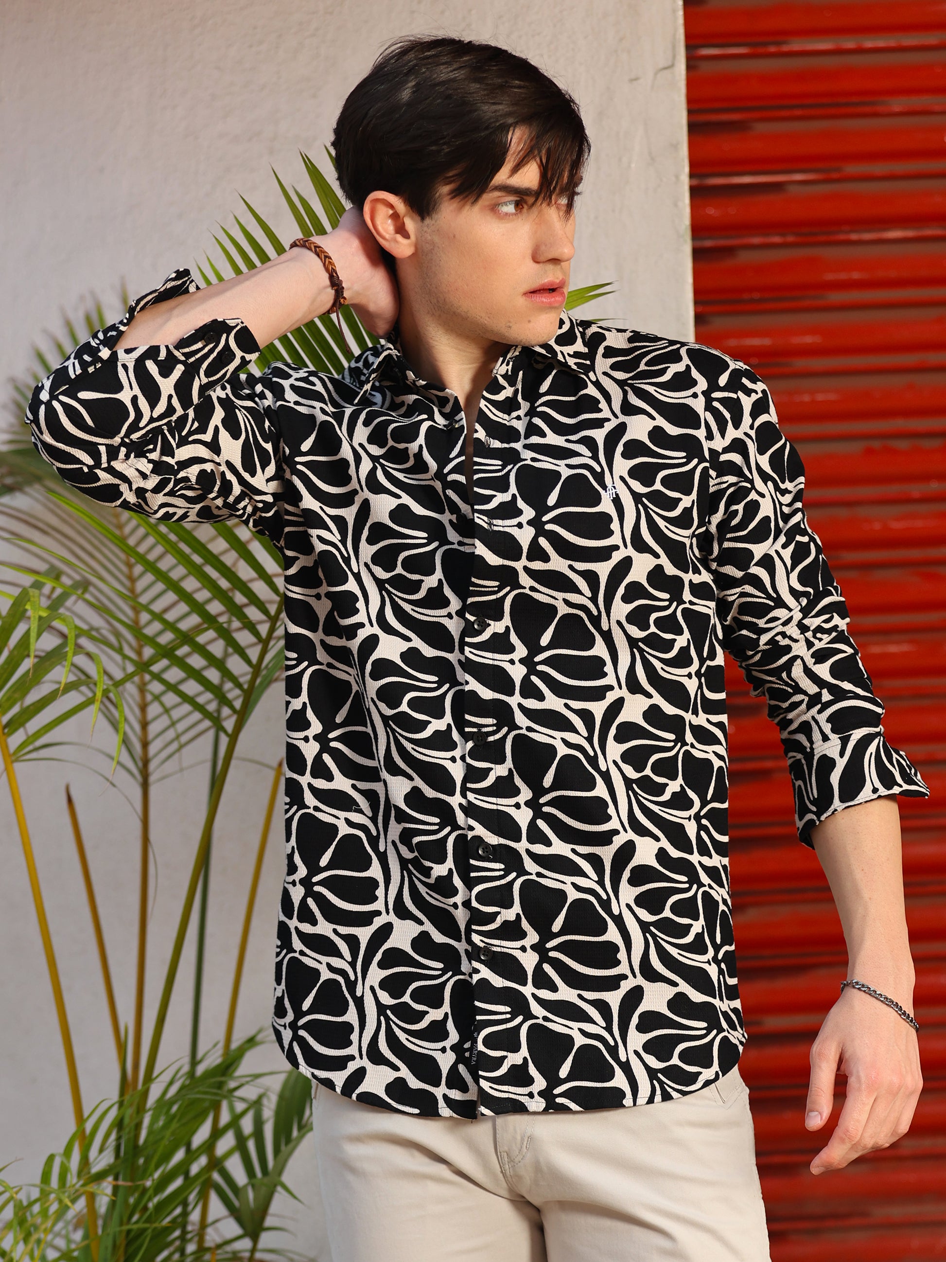 Stylish man wearing monochrome printed shirt with grey jeans and sunglasses