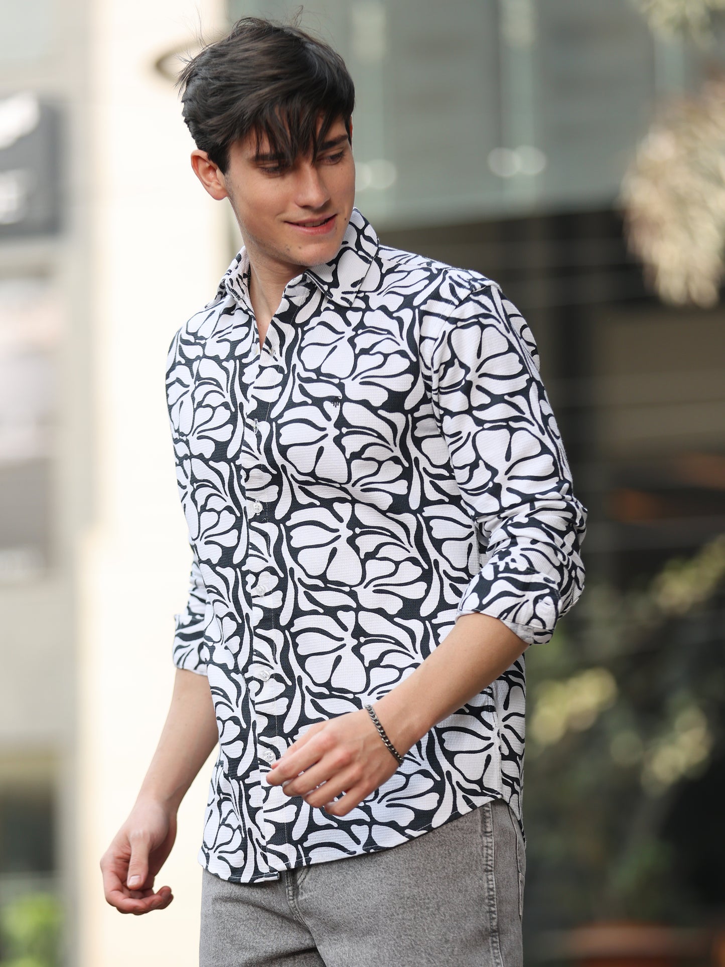 Stylish man wearing monochrome printed shirt with grey jeans