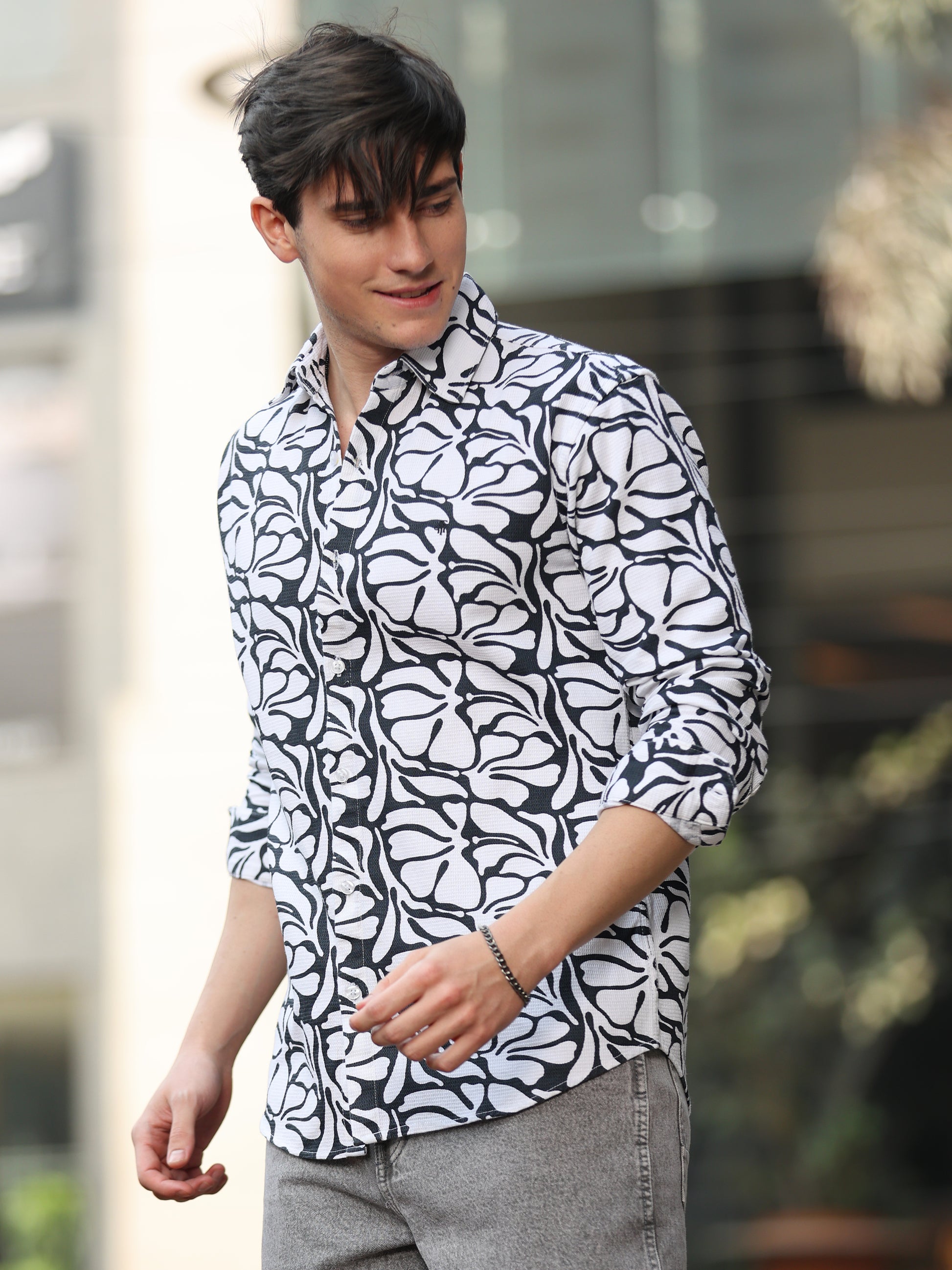 Stylish man wearing monochrome printed shirt with grey jeans