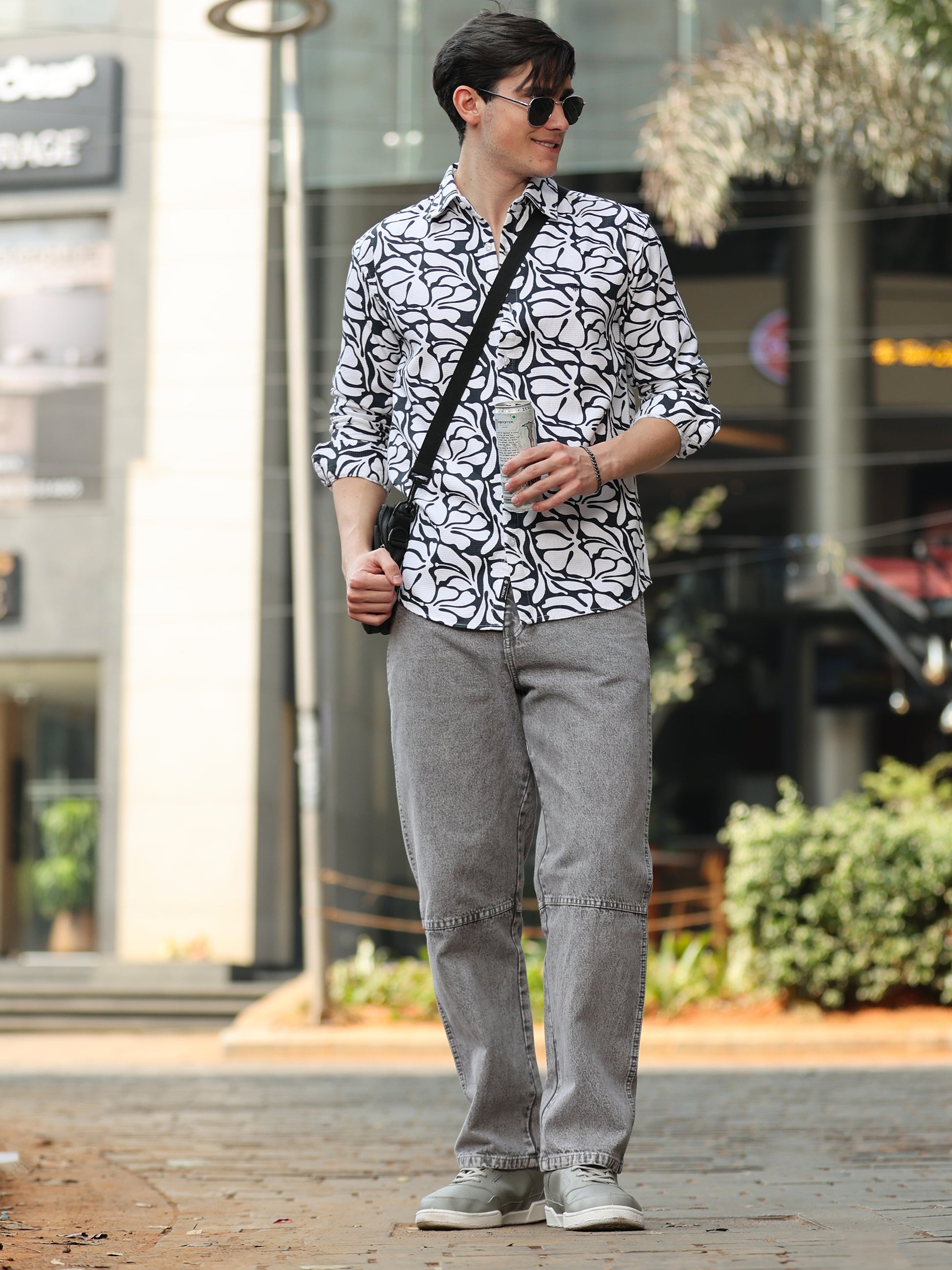 Men's black and white designer shirt paired with grey denim and sneakers