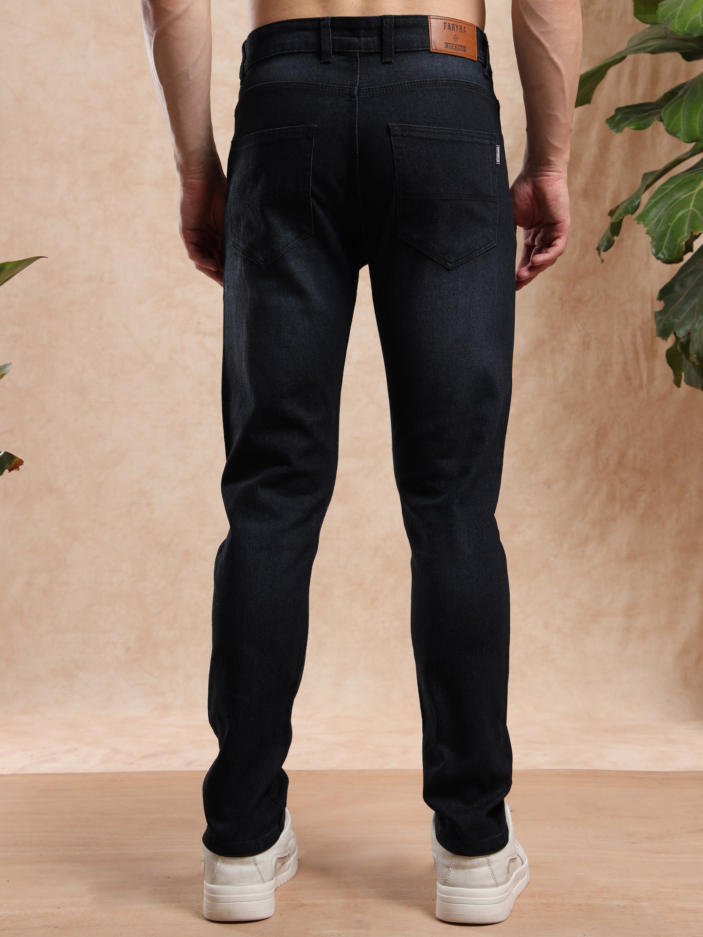 Person wearing black pants with a neutral background